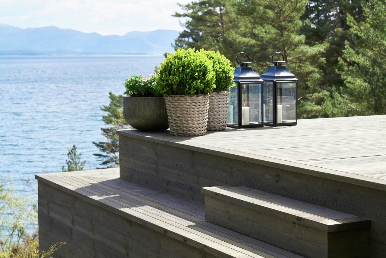 Grått terrassegulv med blomsterpotter og lykter