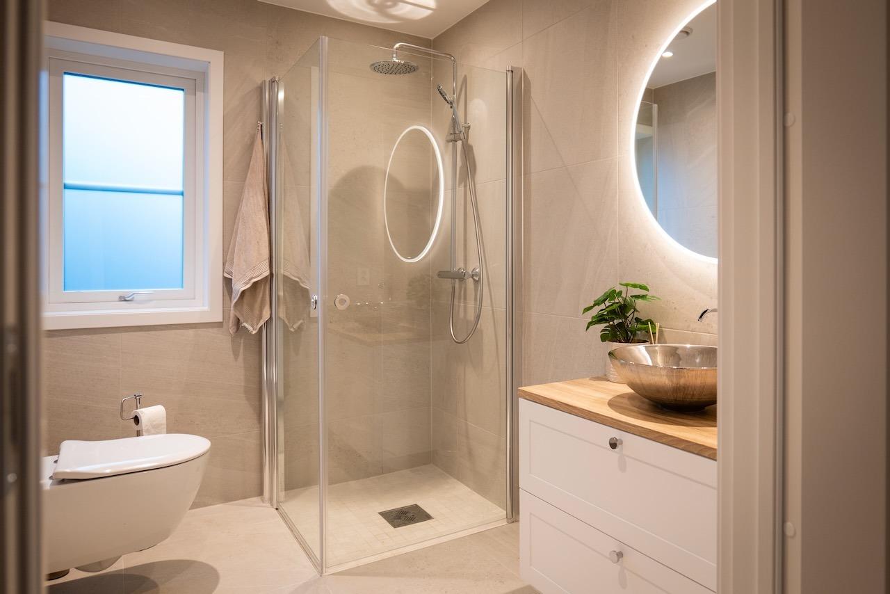 Baderommene er stilrene med høy standard og flotte detaljer, slik som det bakbelyste speilet på bildet