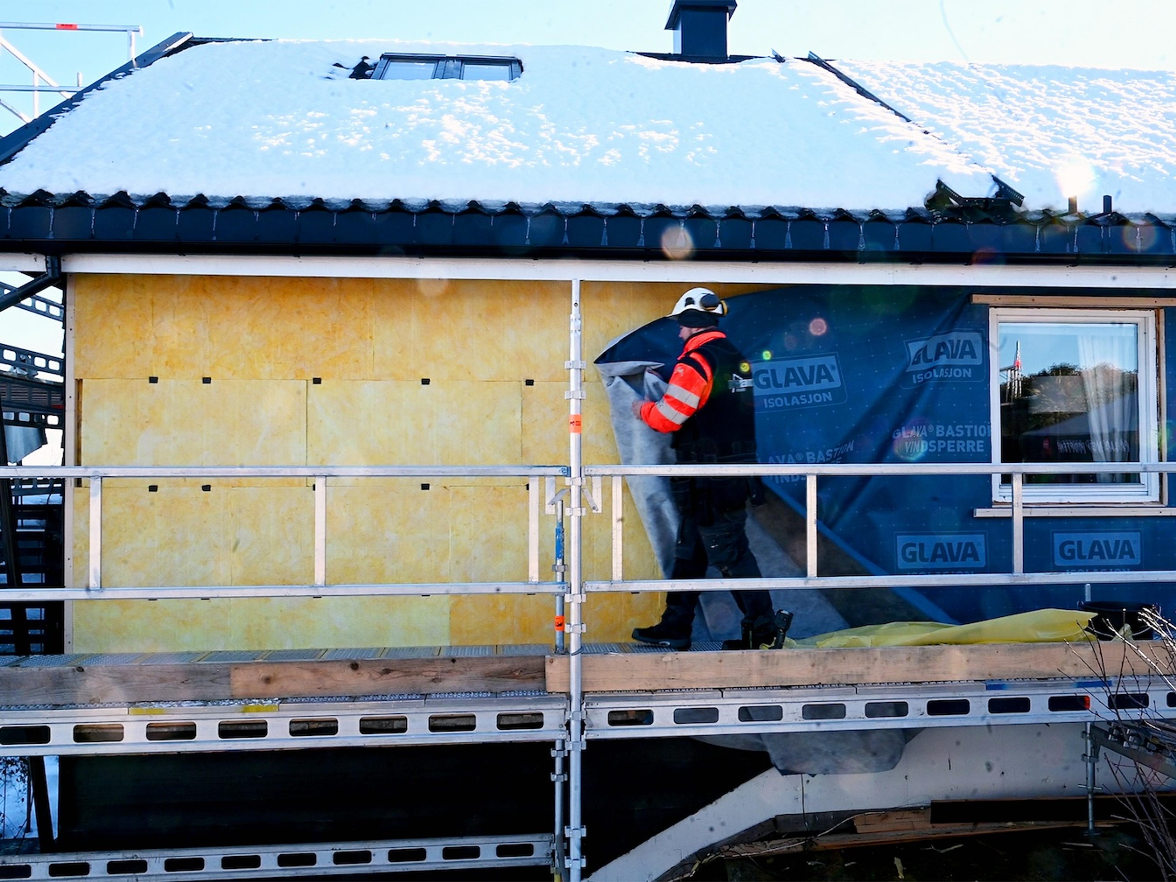 En håndverker som isolerer huset utvendig med Glava