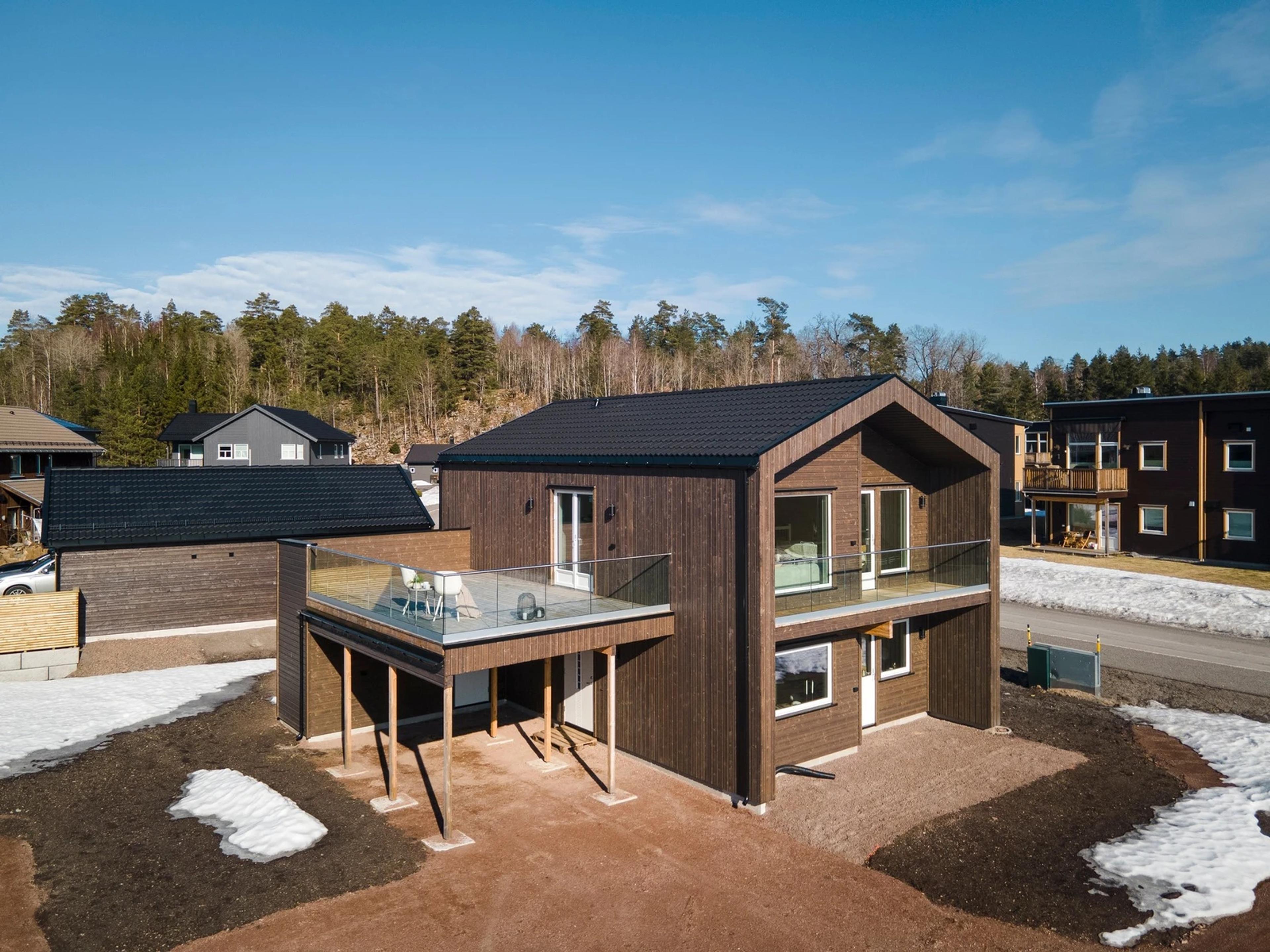 Enebolig i funkisstil med brun kledning og stor terrasse.