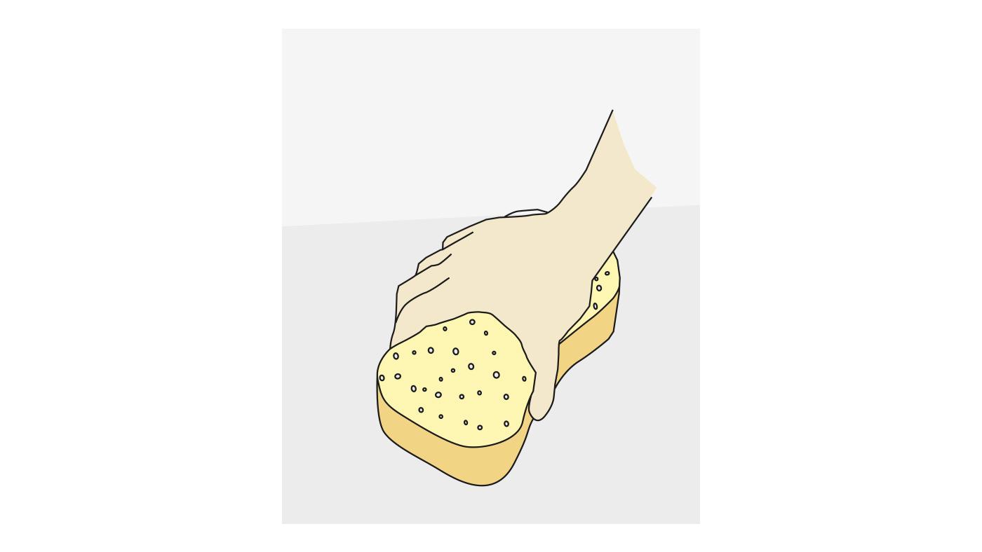Hand som trycker på en gul svamp