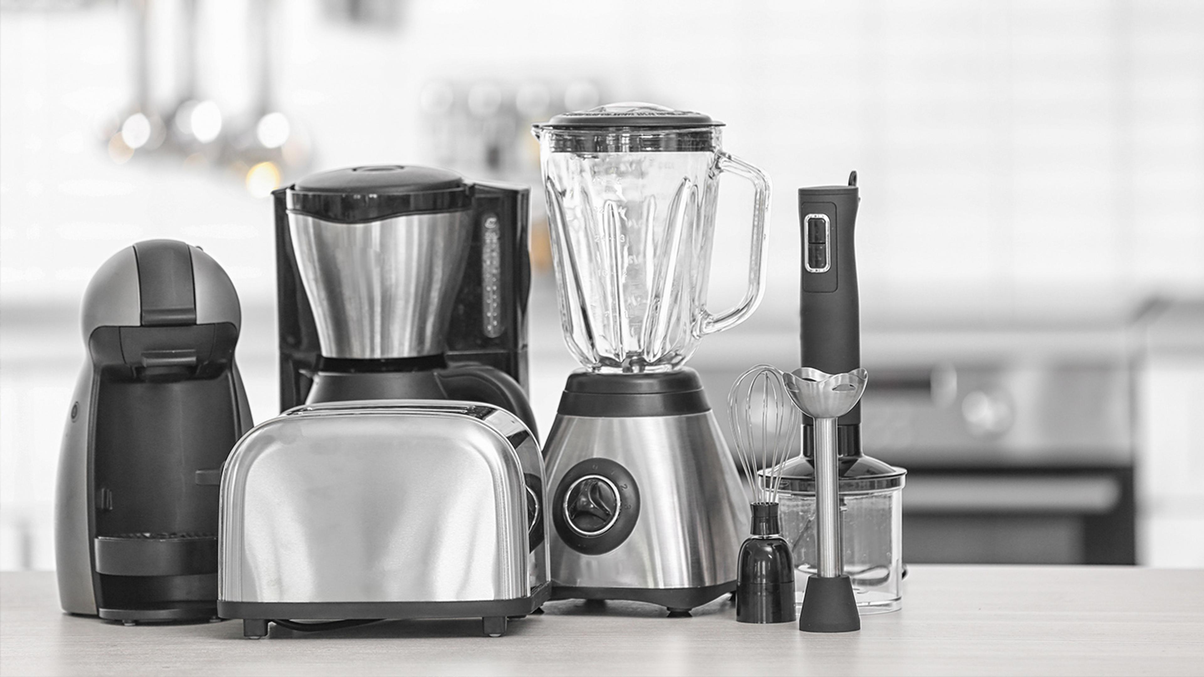 Rad av köksmaskiner i silver och svart: kaffekapselmaskin, brödrost, kaffebryggare, mixer och stavmixer