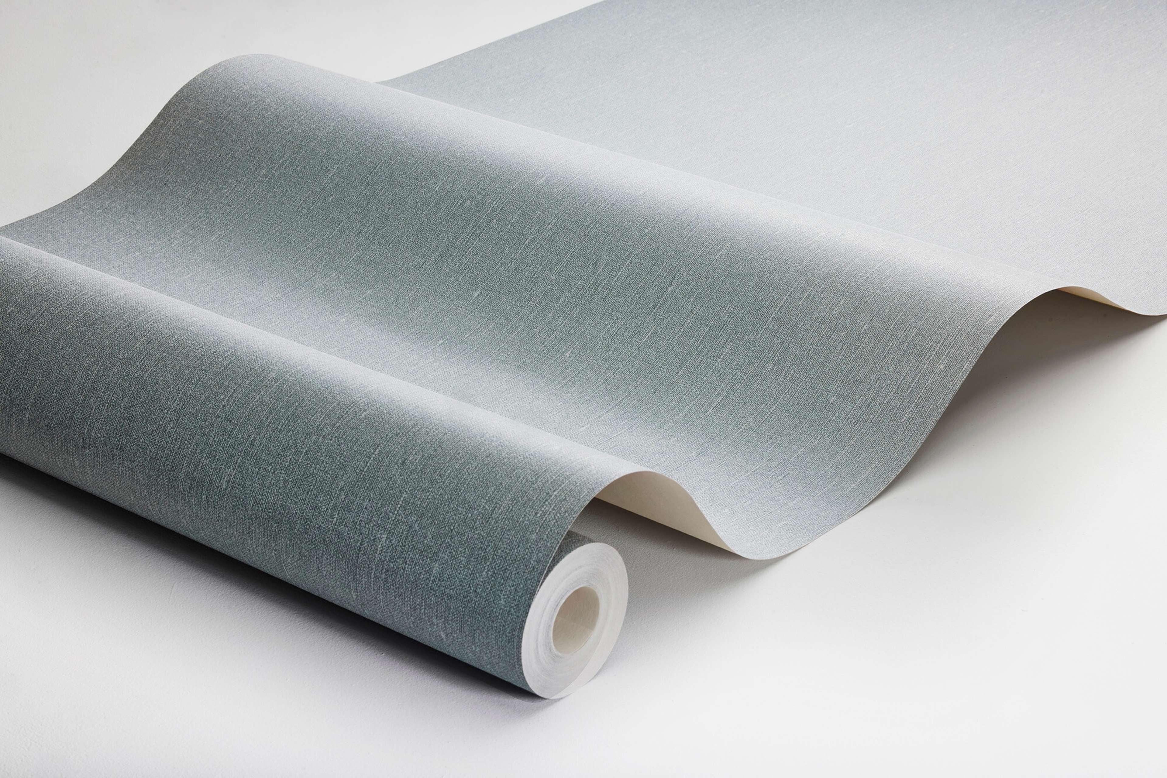 Dusty Denim tapet med enfargat, textilimitation mönster i blå. Från kollektionen Linen. Nonwoven-material. Passar i vardagsrum och matsal.