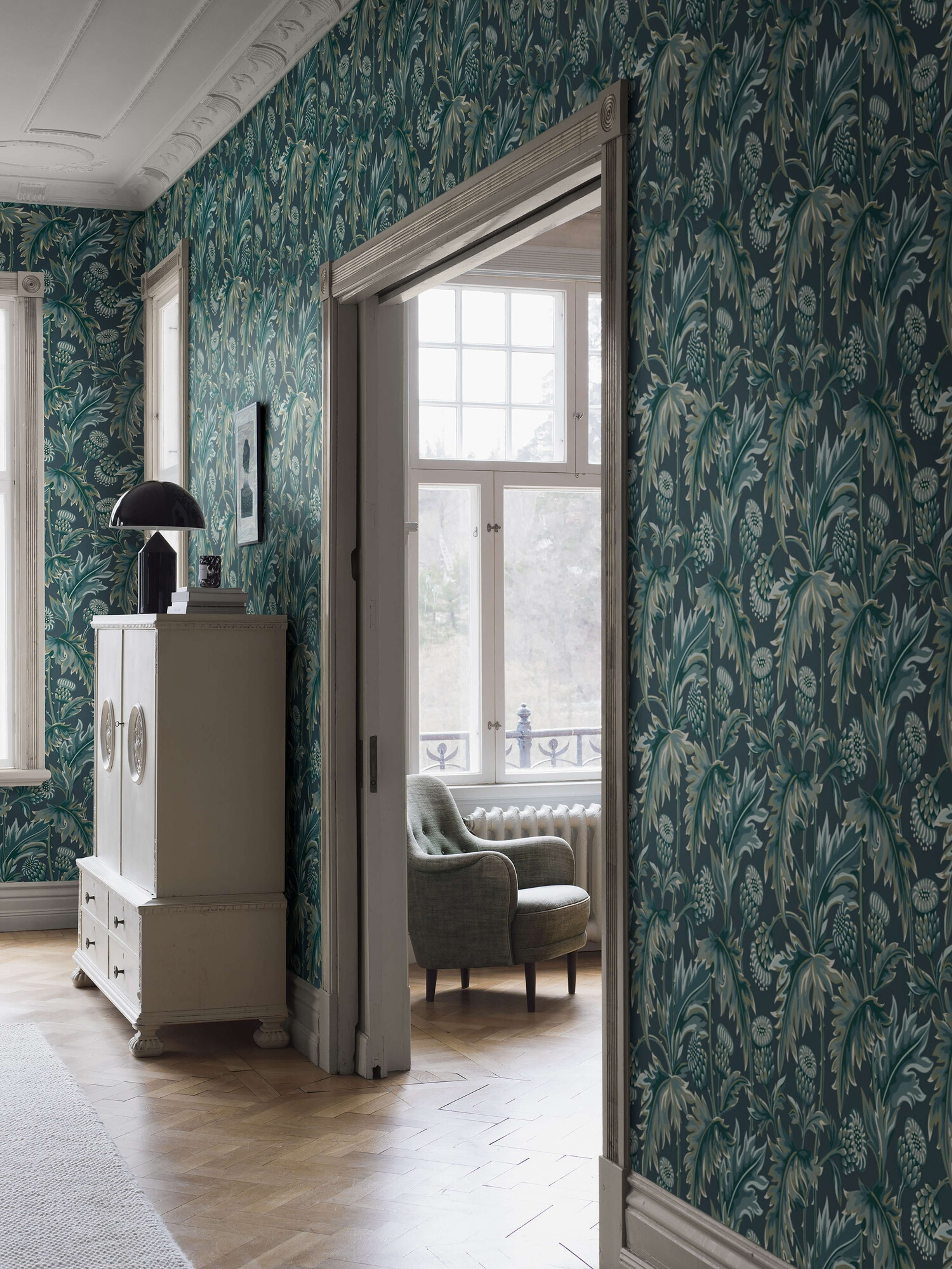 Treasured Thistle tapet i blå nyanser tapet med botaniskt, blommigt mönster i blå. Från kollektionen Treasured. Nonwoven-material med förskjuten passning. Passar i kök, hall och arbetsrum.