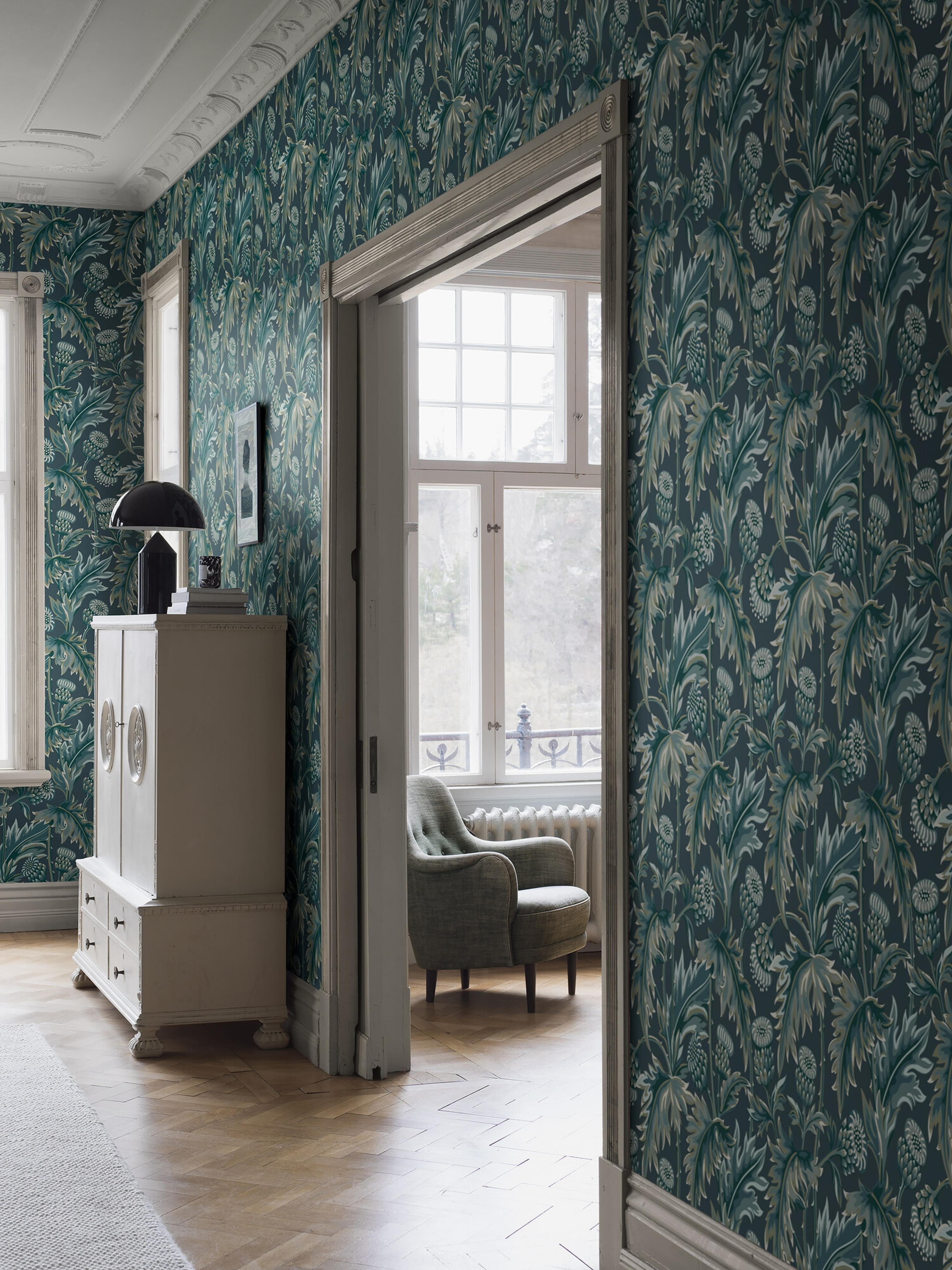 Treasured Thistle tapet i blå nyanser tapet med botaniskt, blommigt mönster i blå. Från kollektionen Treasured. Nonwoven-material med förskjuten passning. Passar i kök, hall och arbetsrum.