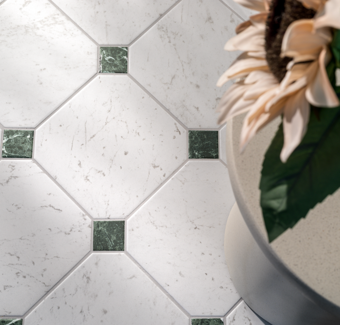 Diagonal white marble tiles with dark green square accents, next to a flower in a vase.