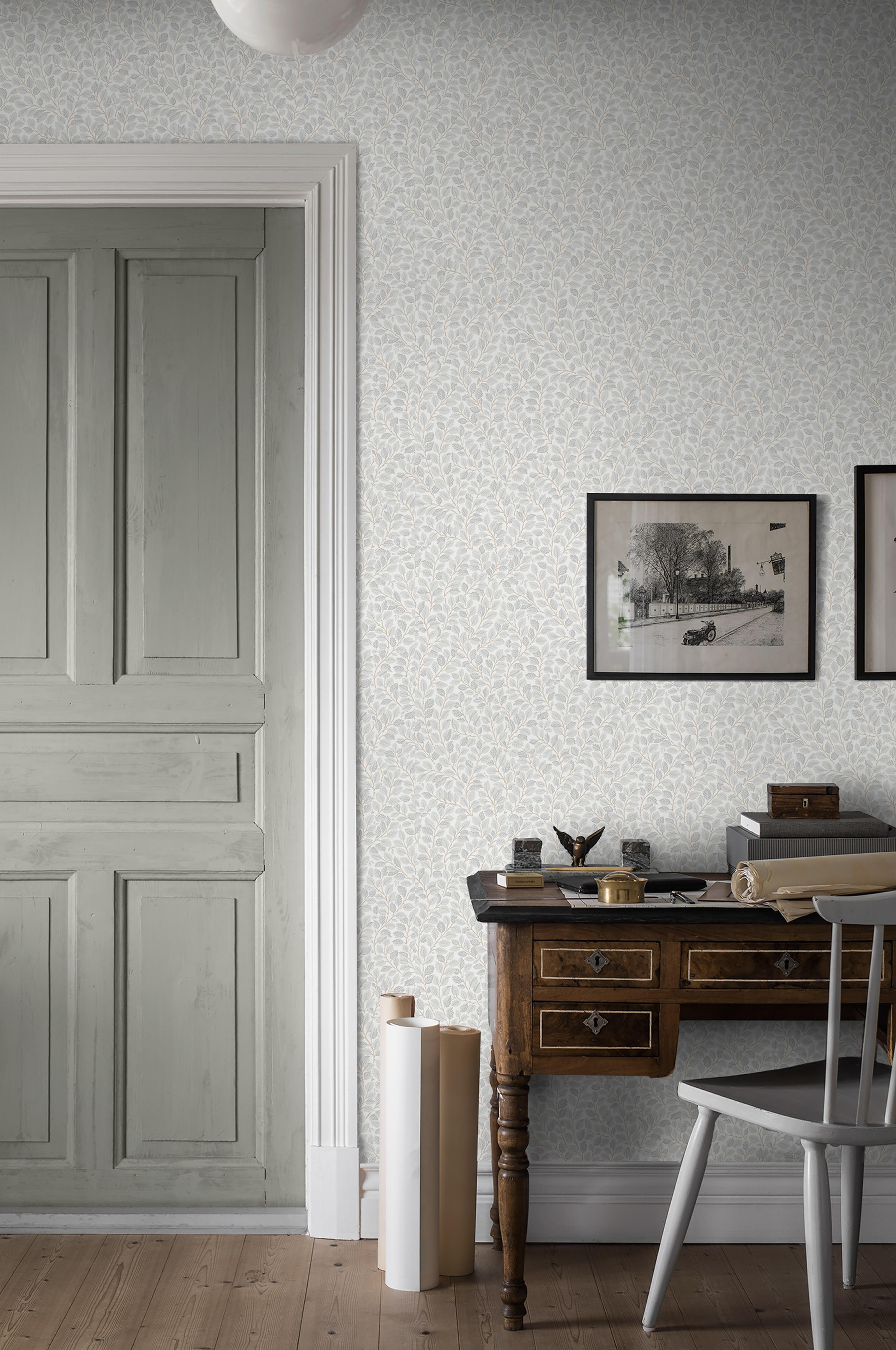 Hazel småbladig, grå/beige tapet från Boråstapeter med botaniskt mönster i grå och beige. Från kollektionen Falsterbo III. Nonwoven-material med rak passning. Country, city-stil.