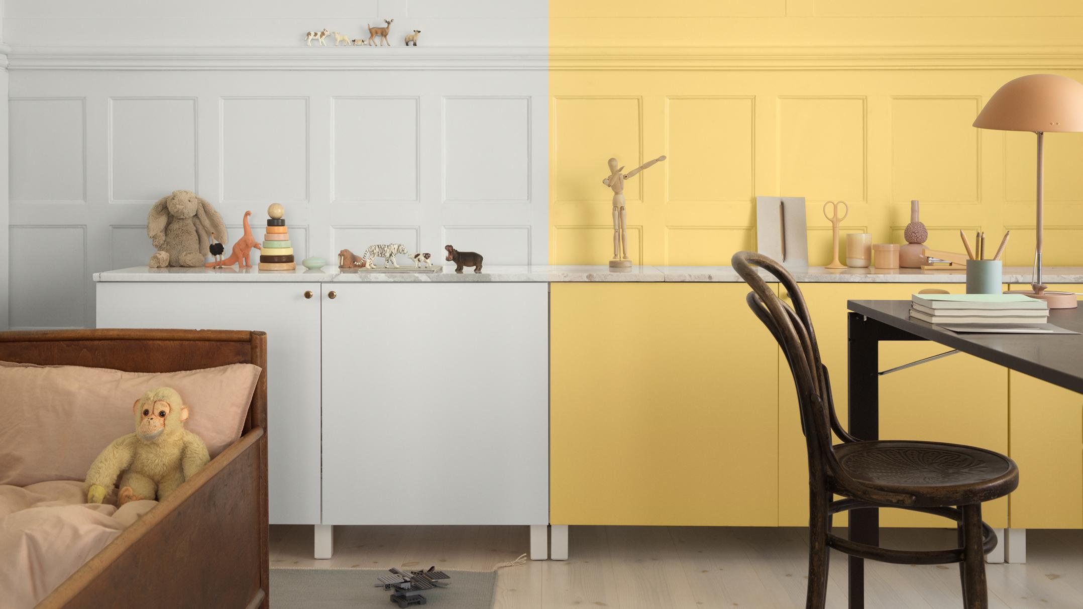 A room split in half: one side white with a child's bed and toys, the other side yellow with a desk and chair.