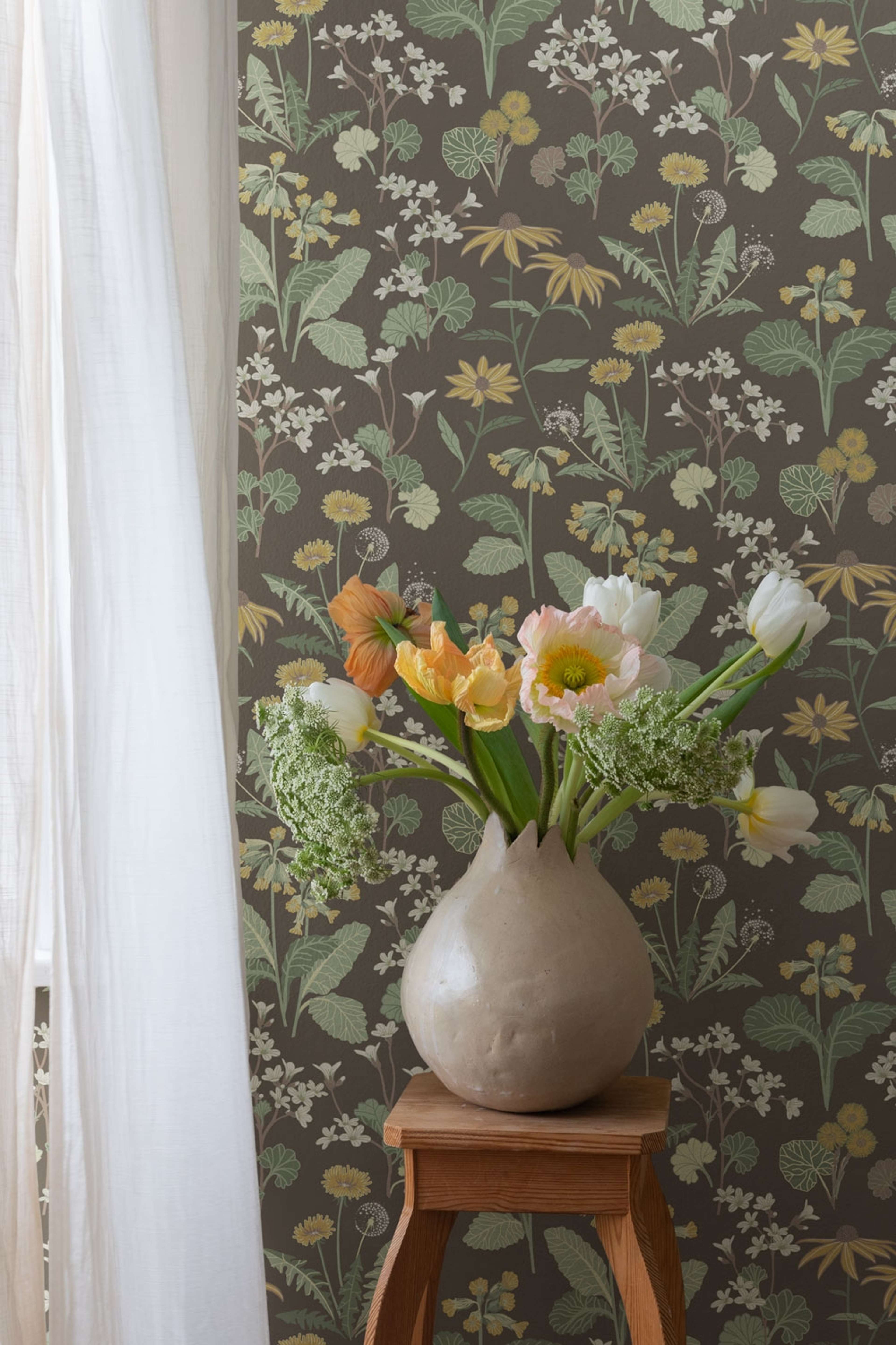 Magdalena, mörkbrun tapet tapet med blommigt mönster i brun. Från kollektionen Örtagård. Nonwoven-material med rak passning.