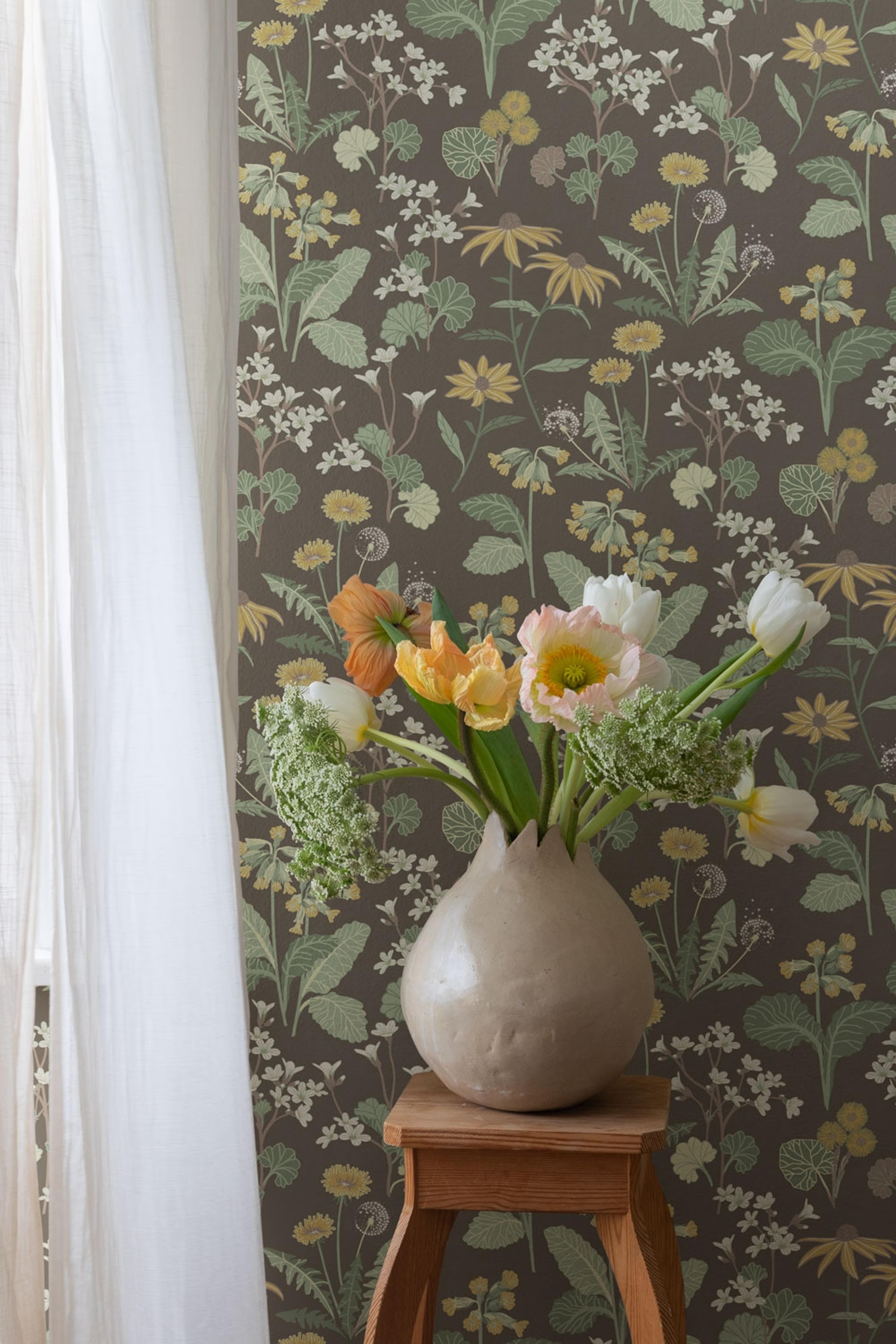 Magdalena, mörkbrun tapet tapet med blommigt mönster i brun. Från kollektionen Örtagård. Nonwoven-material med rak passning.
