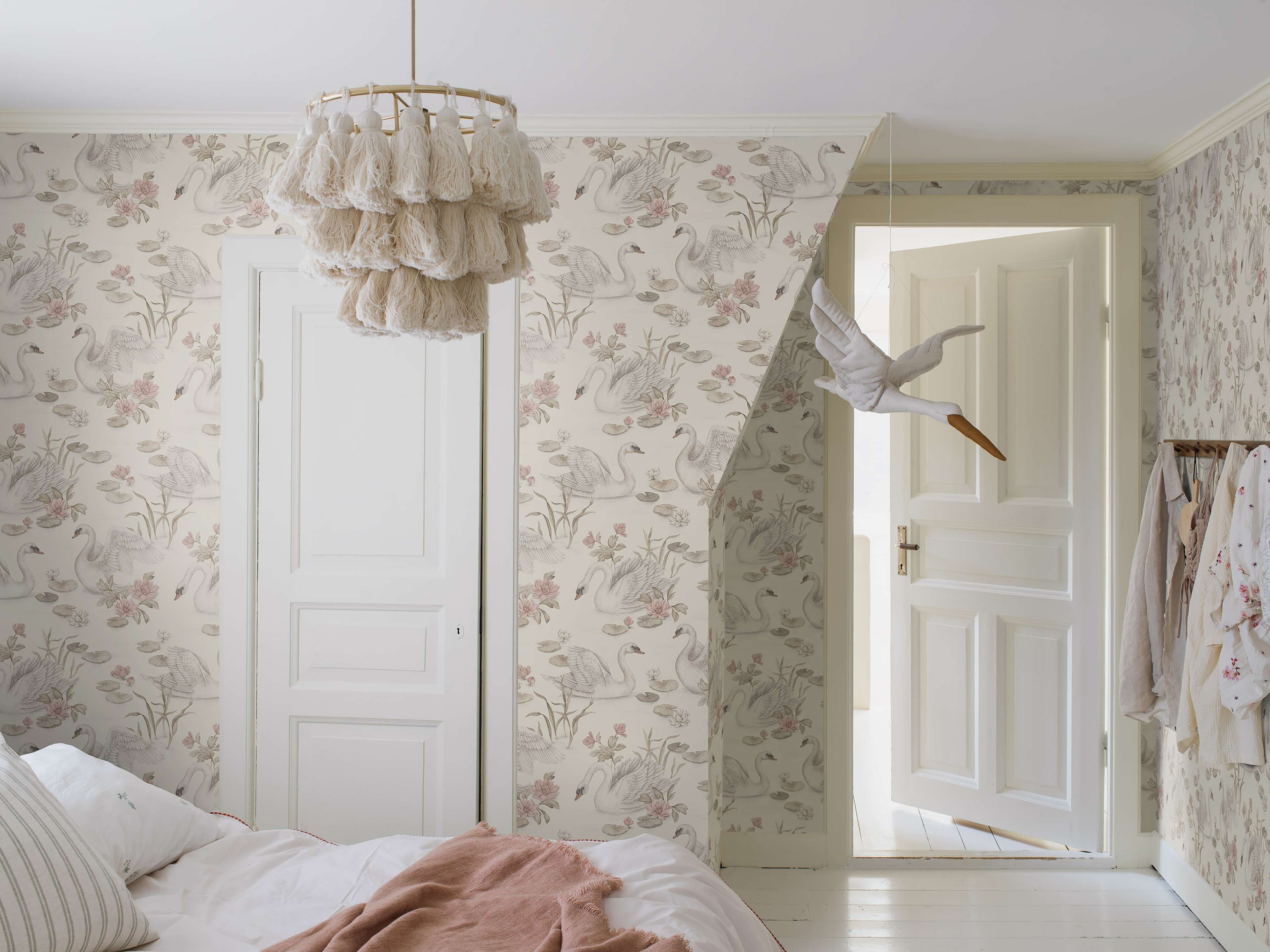 Lily Swan multi, tapet tapet med djur, blommigt mönster i vit och rosa. Från kollektionen Newbie II Wallpaper. Nonwoven-material med förskjuten passning. Passar i sovrum.