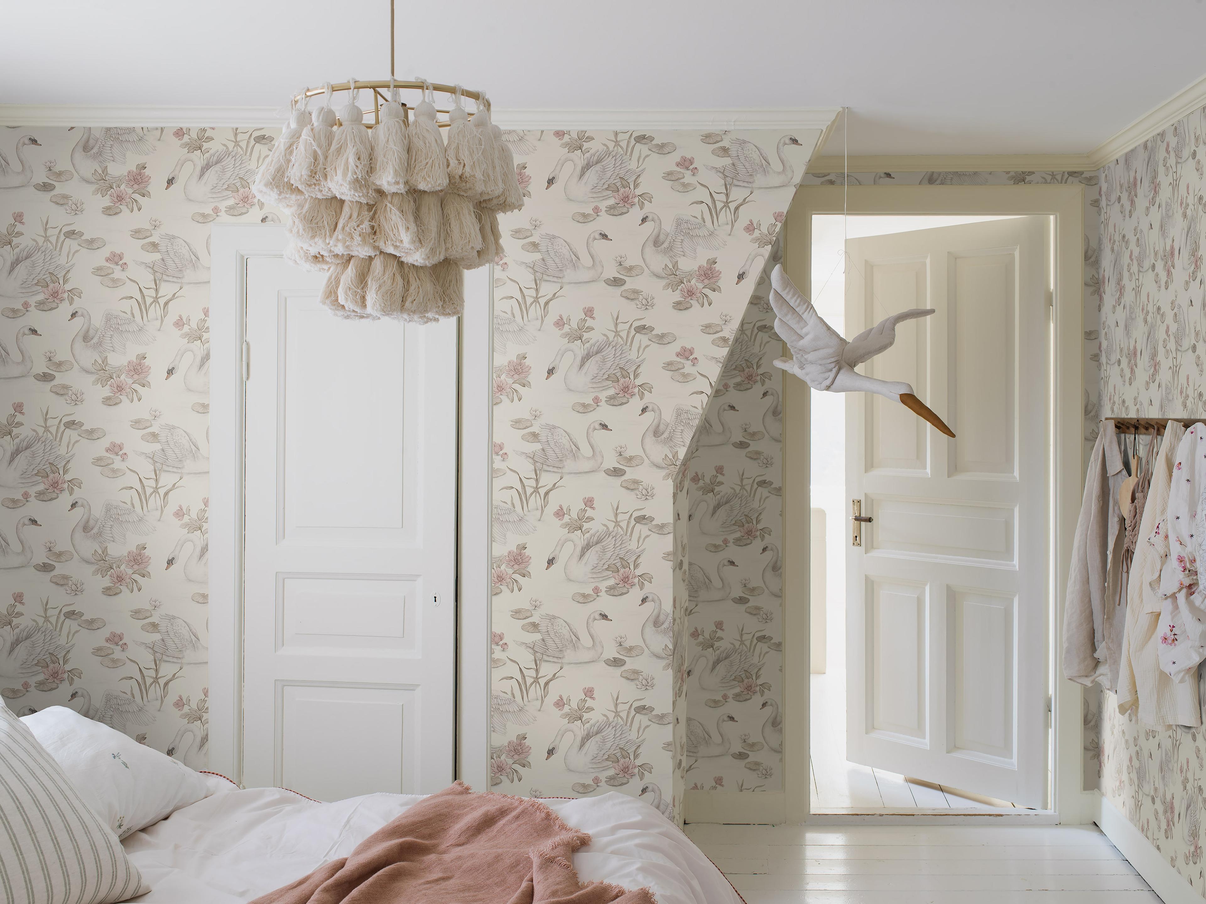 Lily Swan multi, tapet tapet med djur, blommigt mönster i vit och rosa. Från kollektionen Newbie II Wallpaper. Nonwoven-material med förskjuten passning. Passar i sovrum.