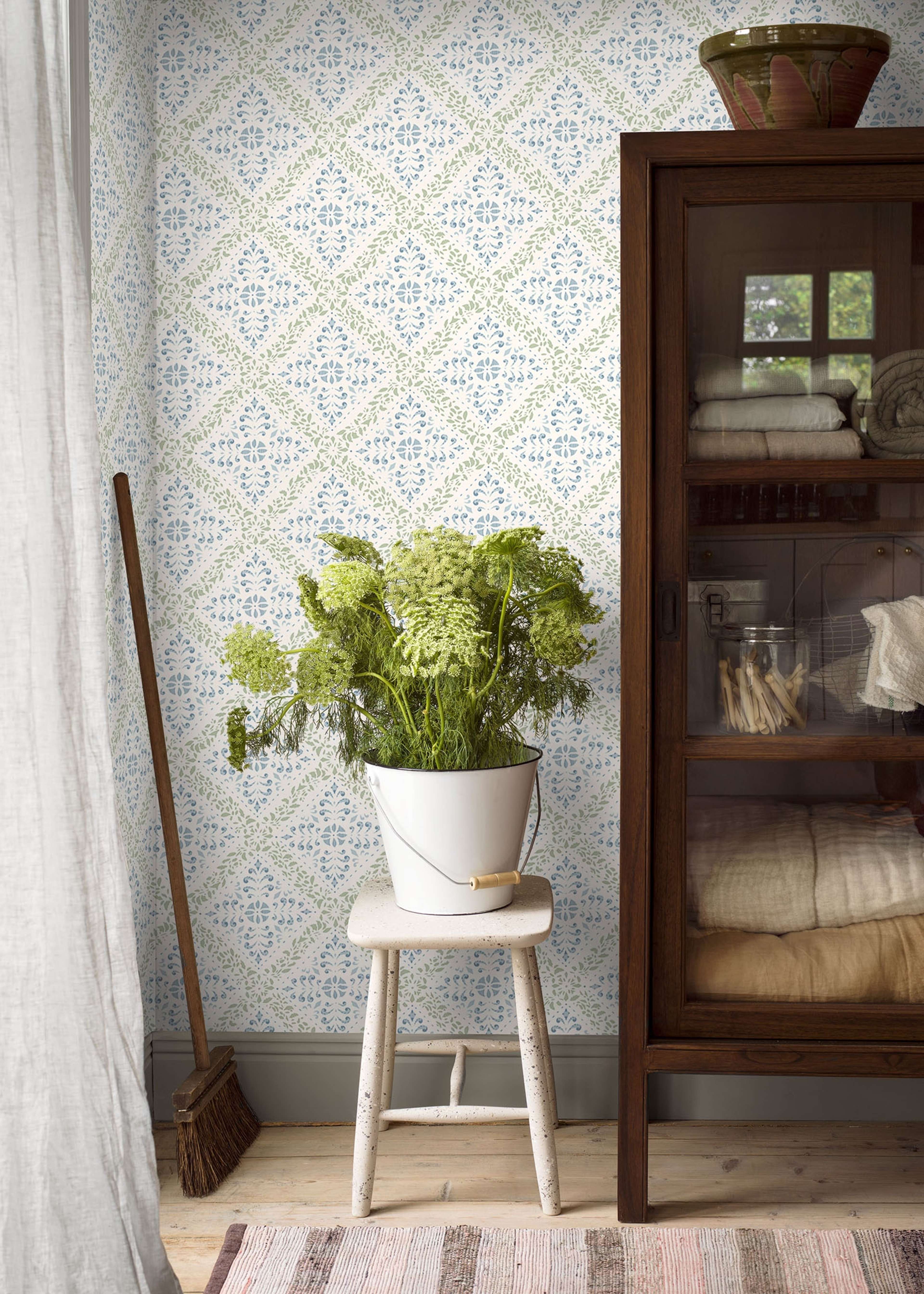 Nyborg tapet från Boråstapeter med geometriskt, blommigt mönster i vit, grön och blå. Från kollektionen anno. Nonwoven-material med rak passning. Passar i sovrum och matsal.