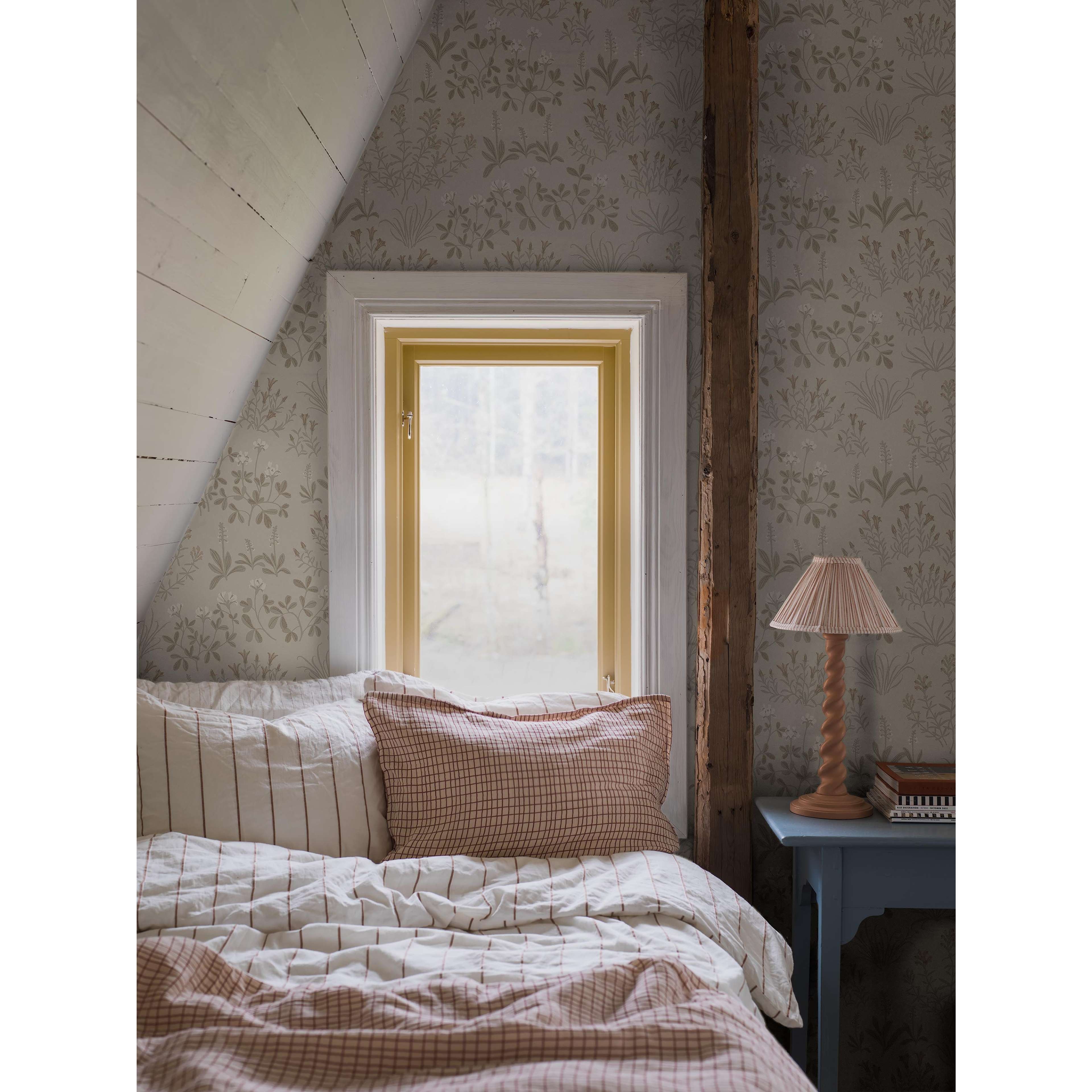 Noras Äng beige, tapet tapet med blommigt, naturochlandskap mönster i beige. Från kollektionen Nordic Folk. Nonwoven-material med förskjuten passning. Passar i sovrum.