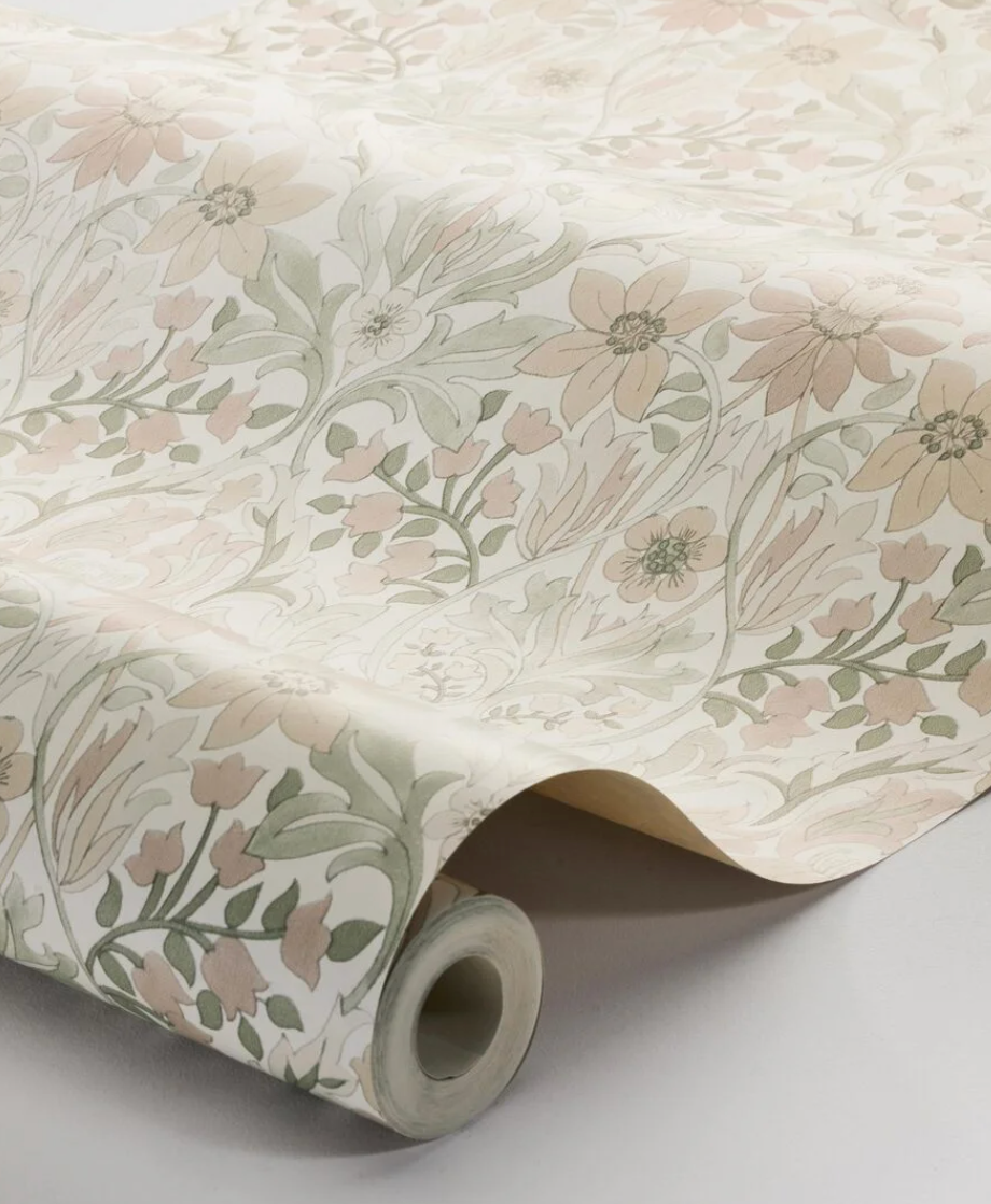 A roll of wallpaper with a peach and green floral pattern.