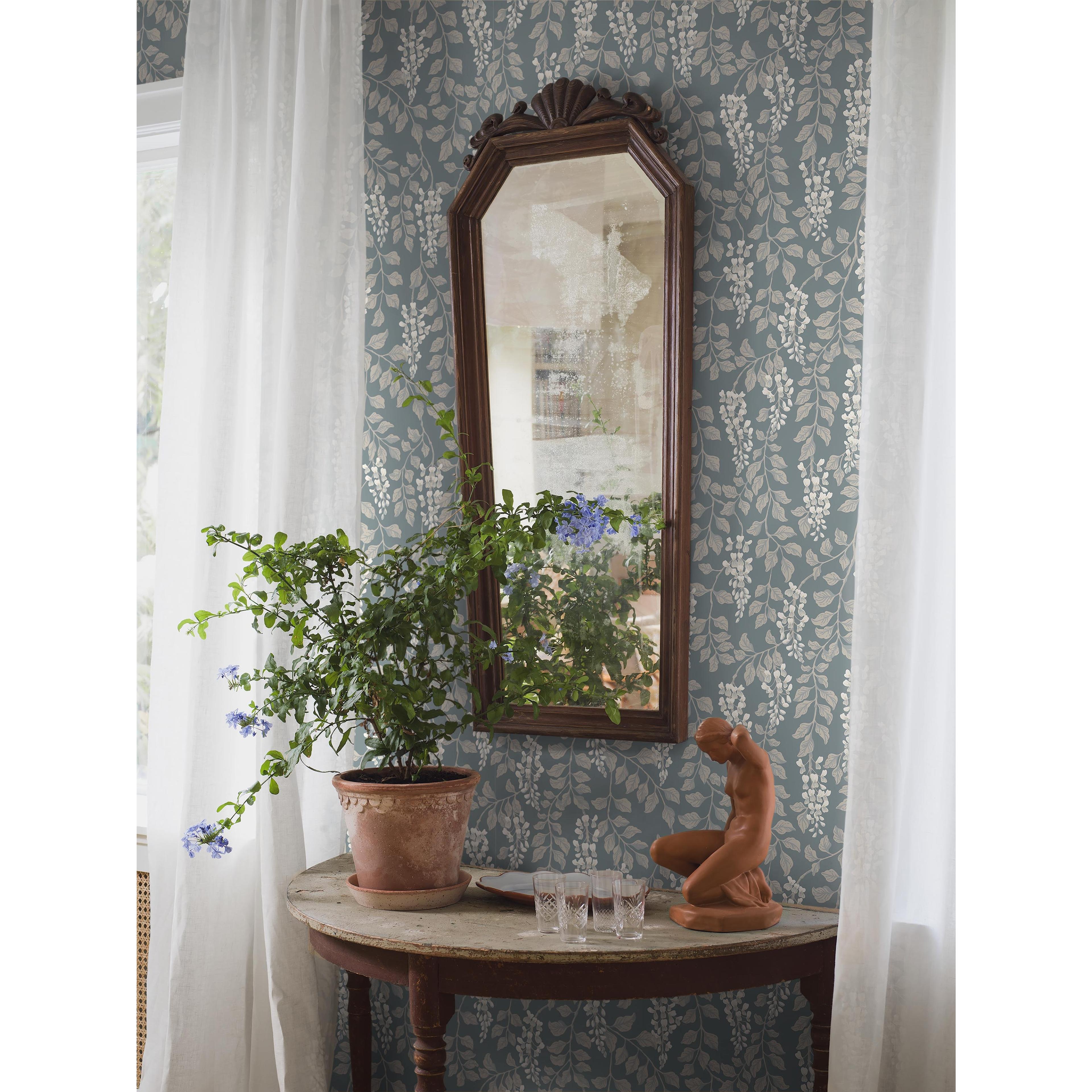 Blåregn blå, tapet tapet med botaniskt, blommigt mönster i blå. Från kollektionen Orangeri. Nonwoven-material med förskjuten passning. Passar i vardagsrum och kök.