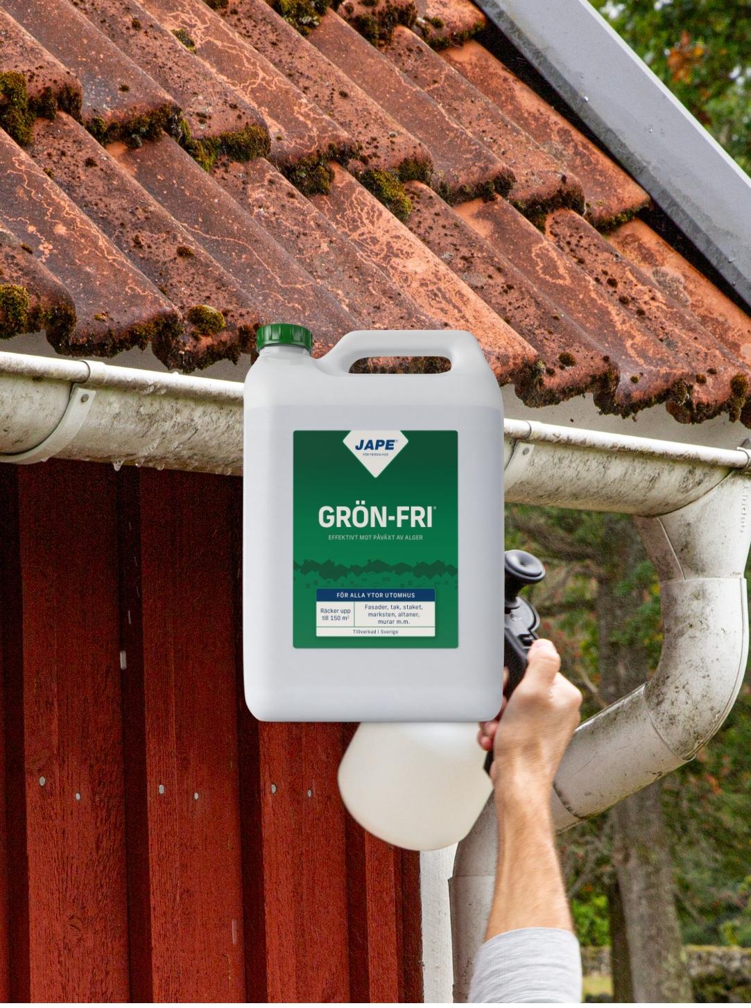A person sprays "GRÖN-FRI" moss remover on a moss-covered tiled roof and gutter.