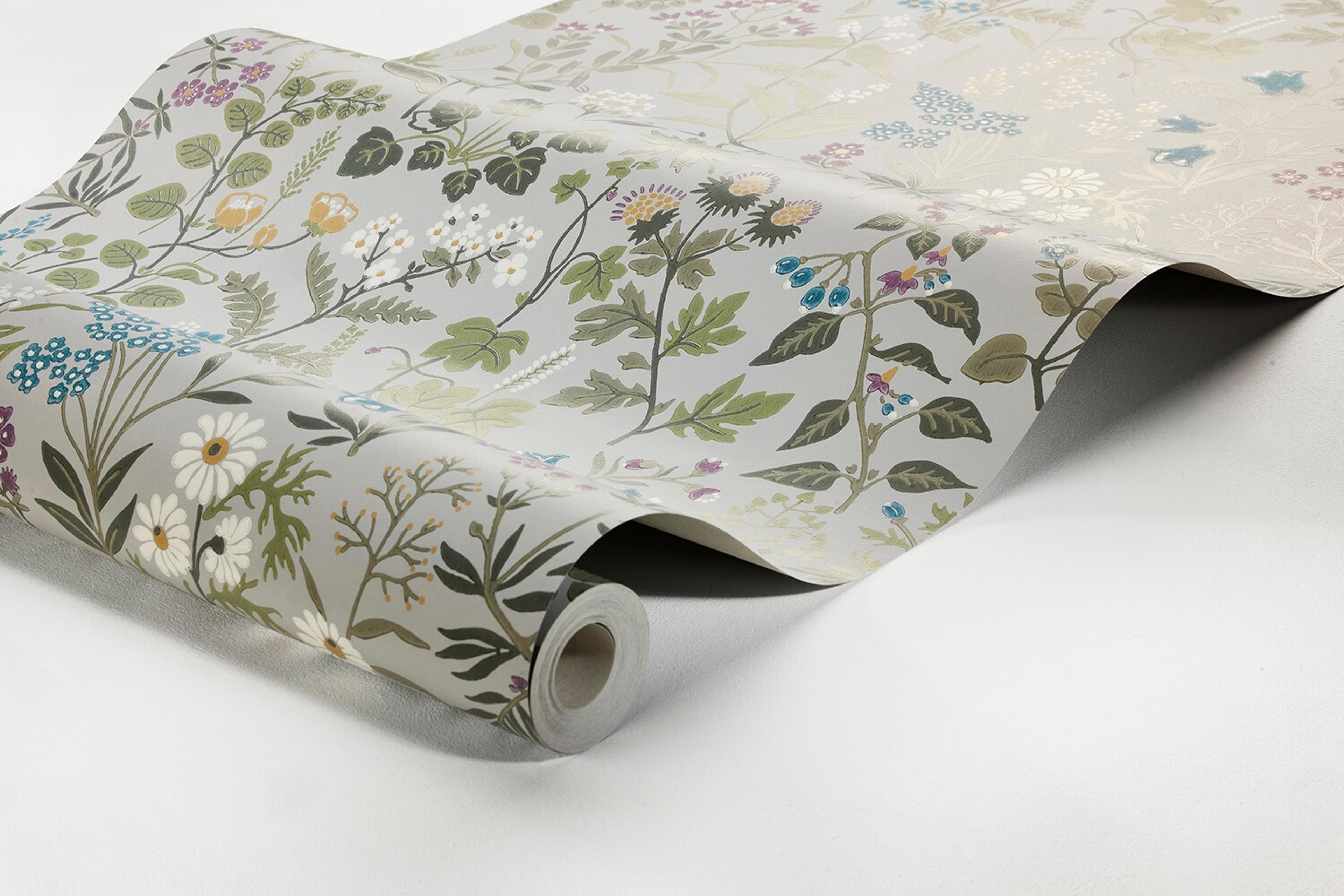 Flora tapet med blommigt mönster i grå. Från kollektionen Alla Tiders Hus. Nonwoven-material med förskjuten passning. Passar i vardagsrum, matsal och kök.
