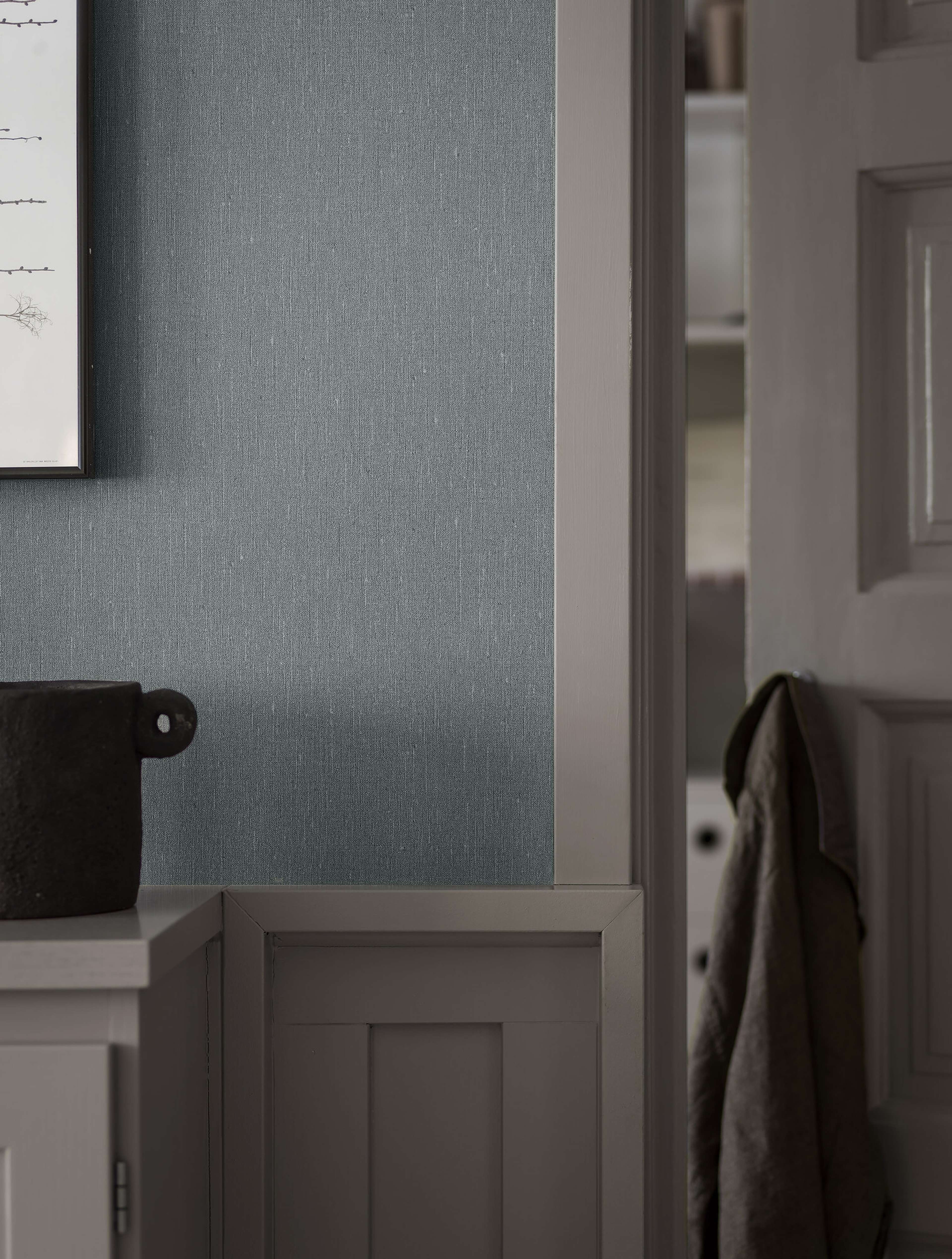 Dusty Denim tapet med enfargat, textilimitation mönster i blå. Från kollektionen Linen. Nonwoven-material. Passar i vardagsrum och matsal.