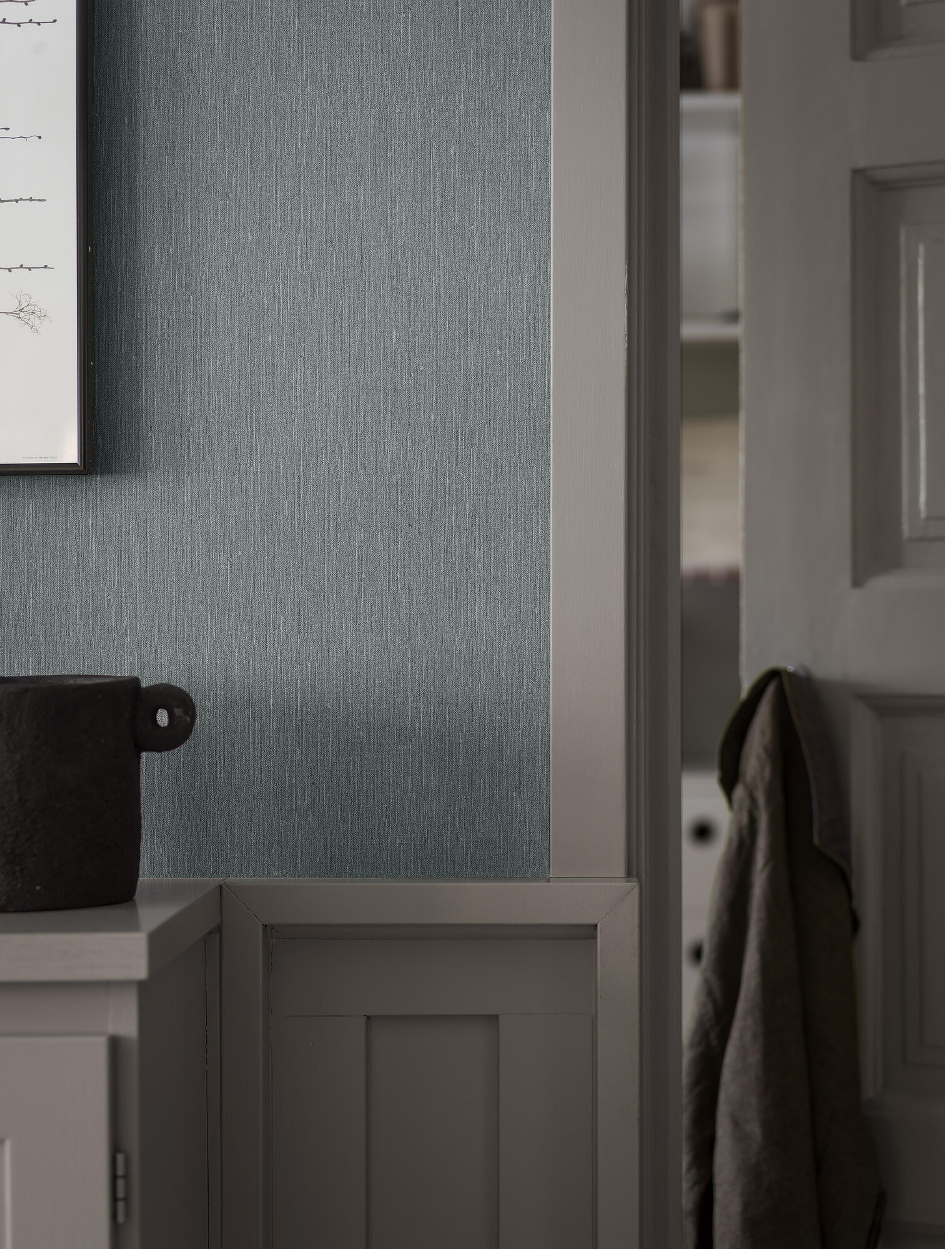Dusty Denim tapet med enfargat, textilimitation mönster i blå. Från kollektionen Linen. Nonwoven-material. Passar i vardagsrum och matsal.