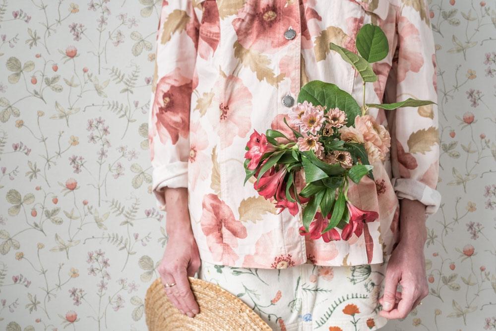 Julia ängsblommor i rosa, rött och orange tapet från Midbec med blommigt mönster i rosa. Från kollektionen Morgongåva. Nonwoven-material med rak passning.