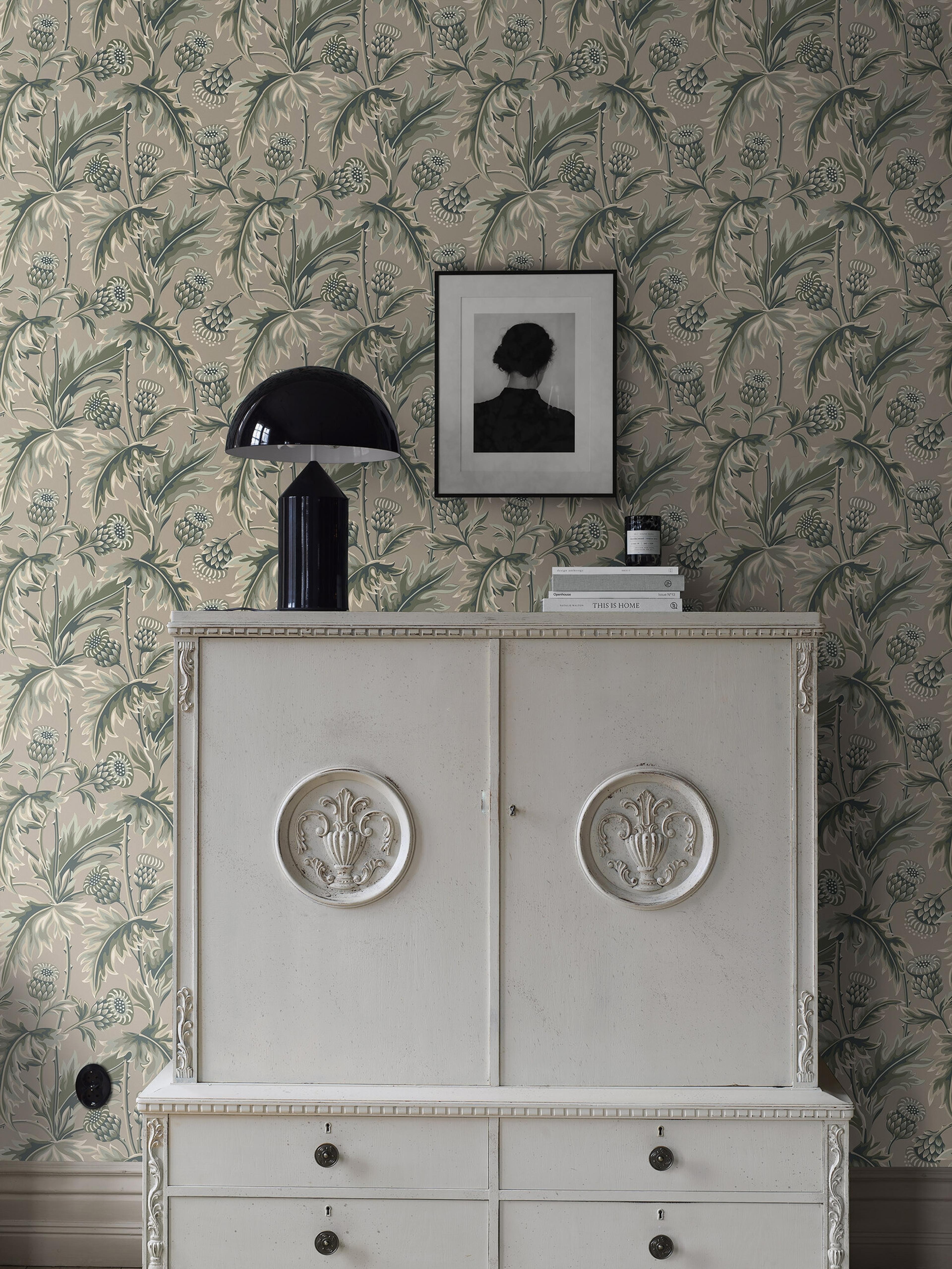 Treasured Thistle tapet i grönt och varmt beige tapet med botaniskt, blommigt mönster i grön. Från kollektionen Treasured. Nonwoven-material med förskjuten passning. Passar i kök, hall och arbetsrum.