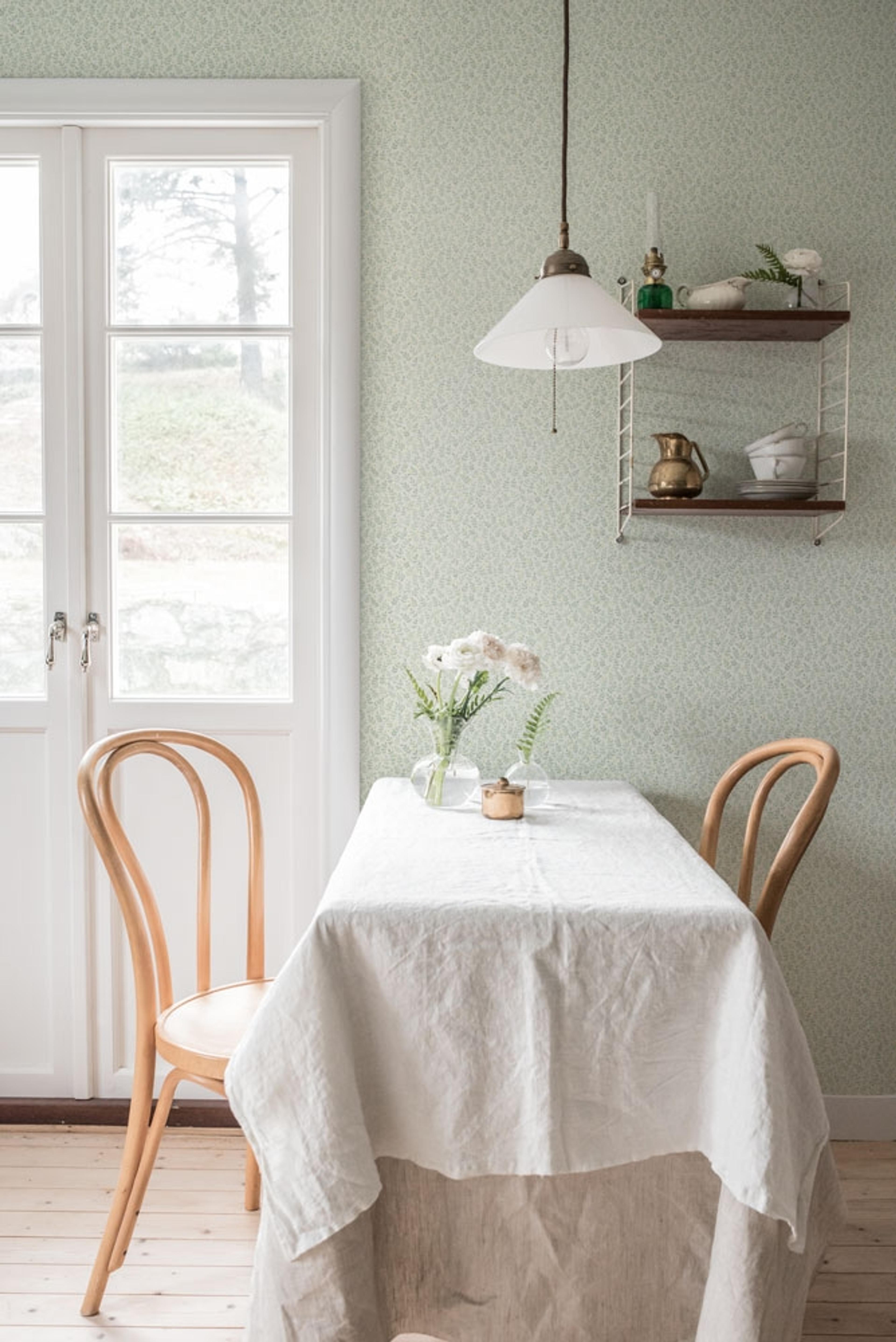 Junis ljus tapet med små blad i grönt tapet från Midbec med botaniskt mönster i vit och grön. Från kollektionen Morgongåva. Nonwoven-material med rak passning.