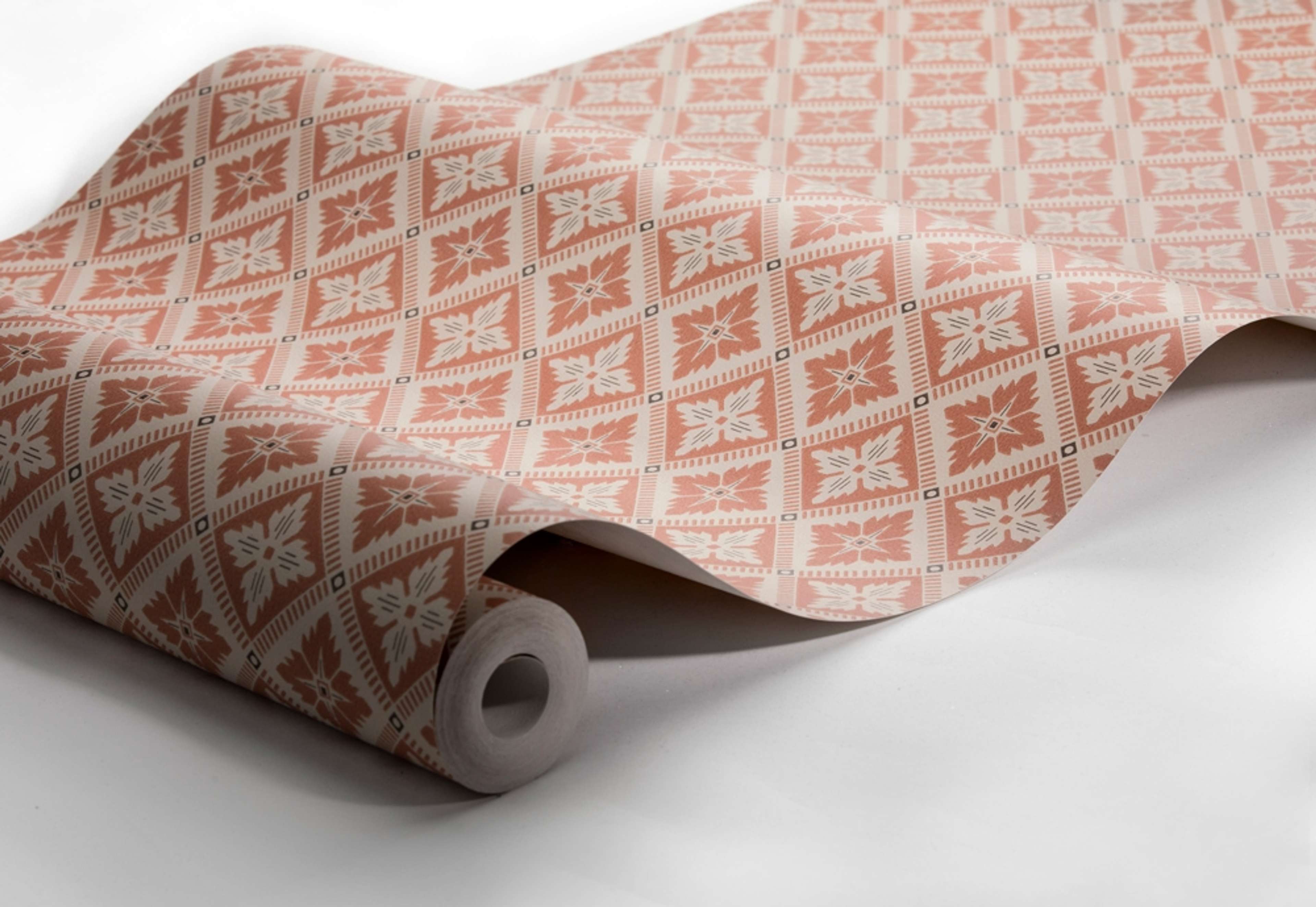 Loka, beige/roströd tapet från Boråstapeter med geometriskt mönster i röd, brun och beige. Från kollektionen anno. Nonwoven-material med rak passning. Passar i sovrum och matsal.