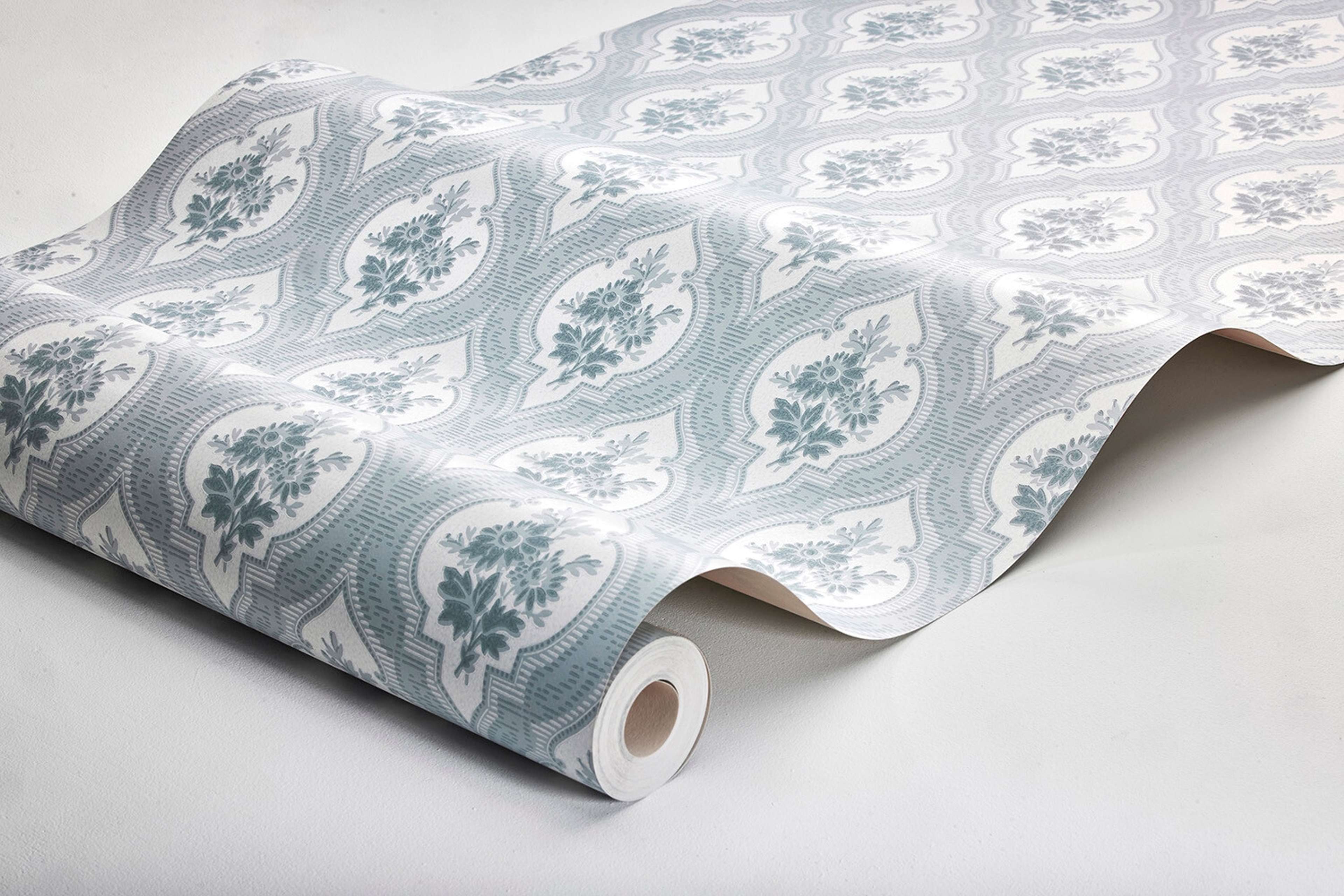 Eternal Flower tapet tapet med blommigt, trellis mönster i blå. Från kollektionen Dreamy Escape. Nonwoven-material med förskjuten passning. Passar i vardagsrum och matsal.