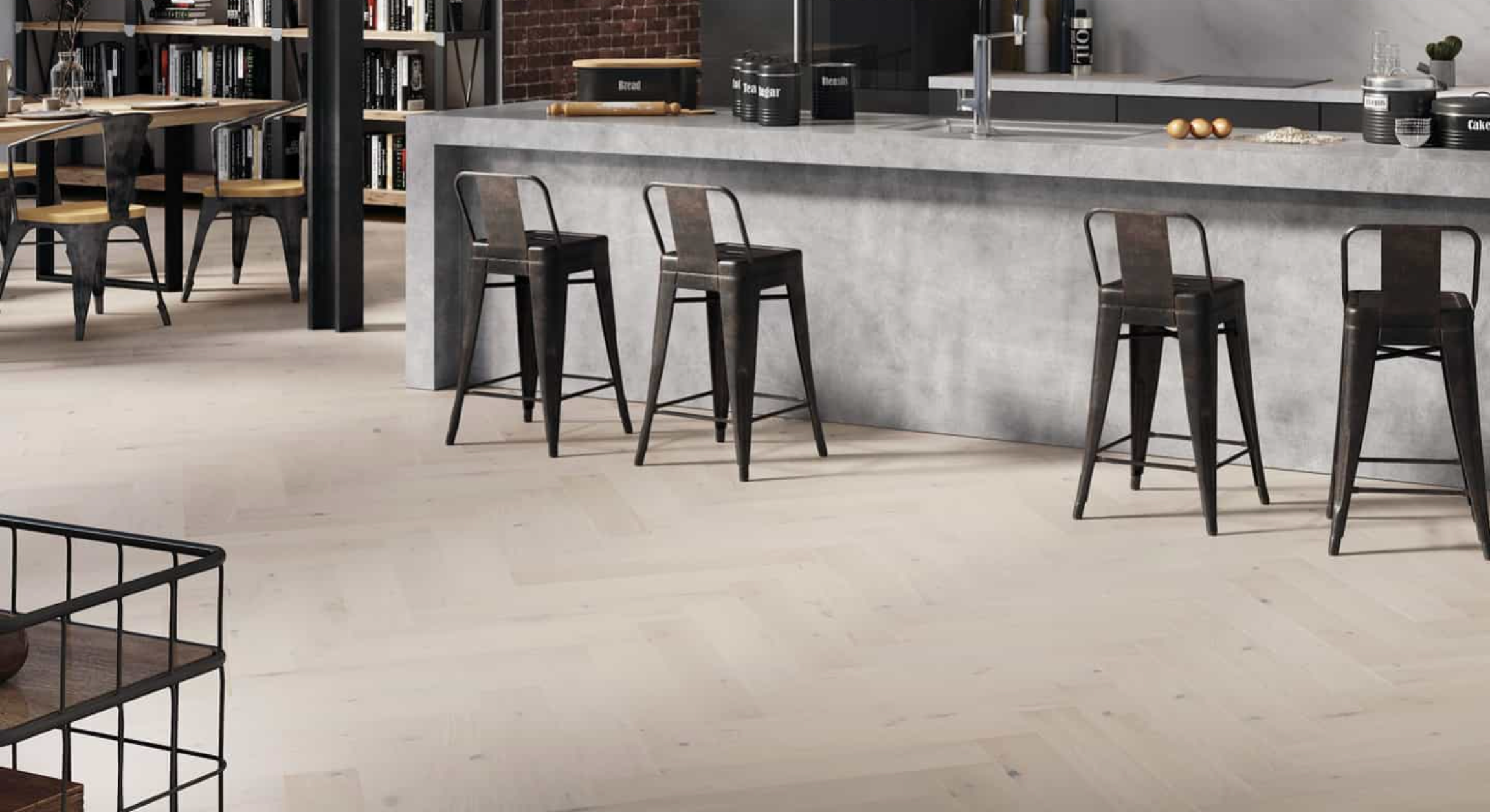 Light herringbone wood floor in an industrial-style kitchen and dining area with a concrete bar.
