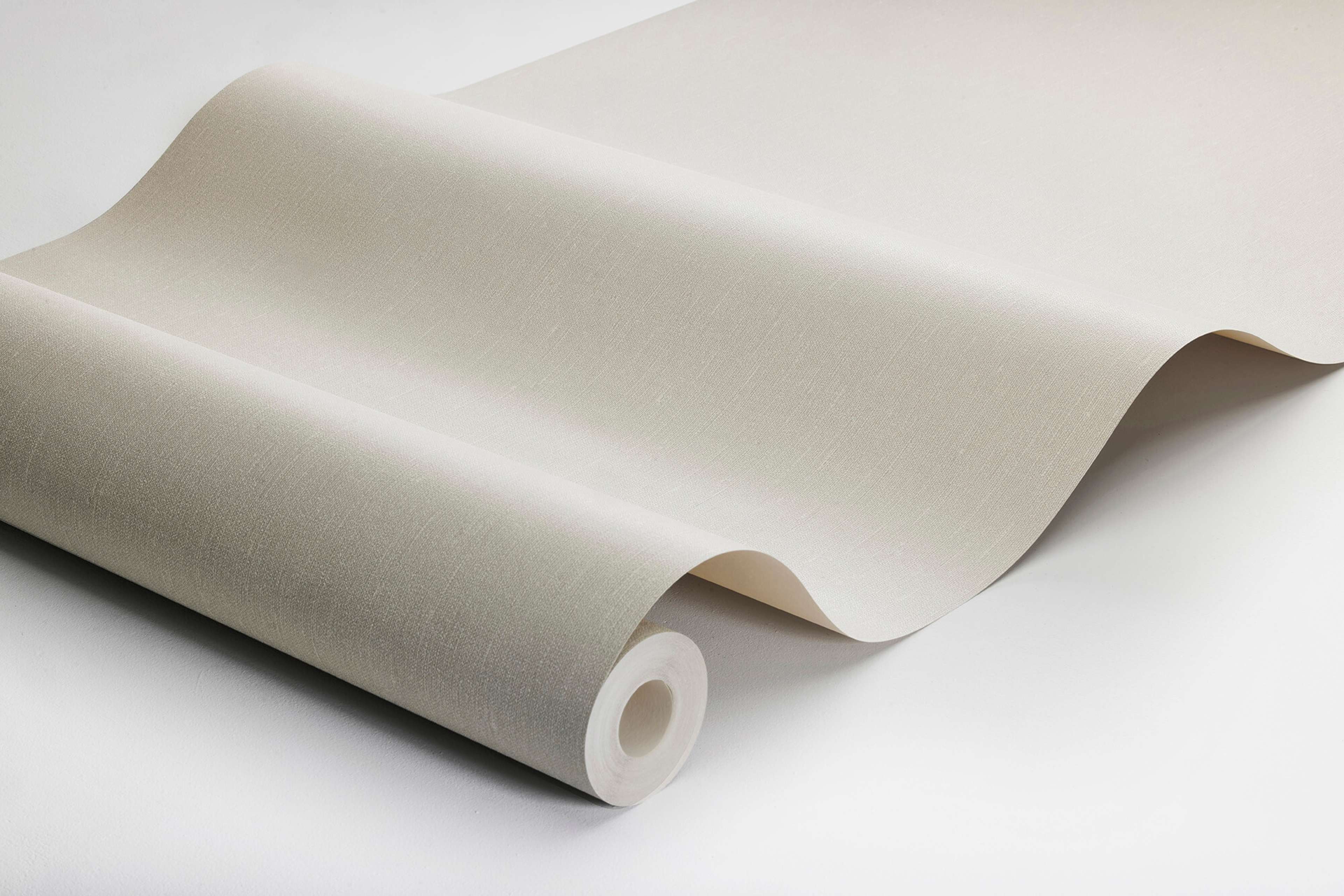 Scandinavian Beige tapet med enfargat, textilimitation mönster i beige. Från kollektionen Linen. Nonwoven-material. Passar i vardagsrum och matsal.