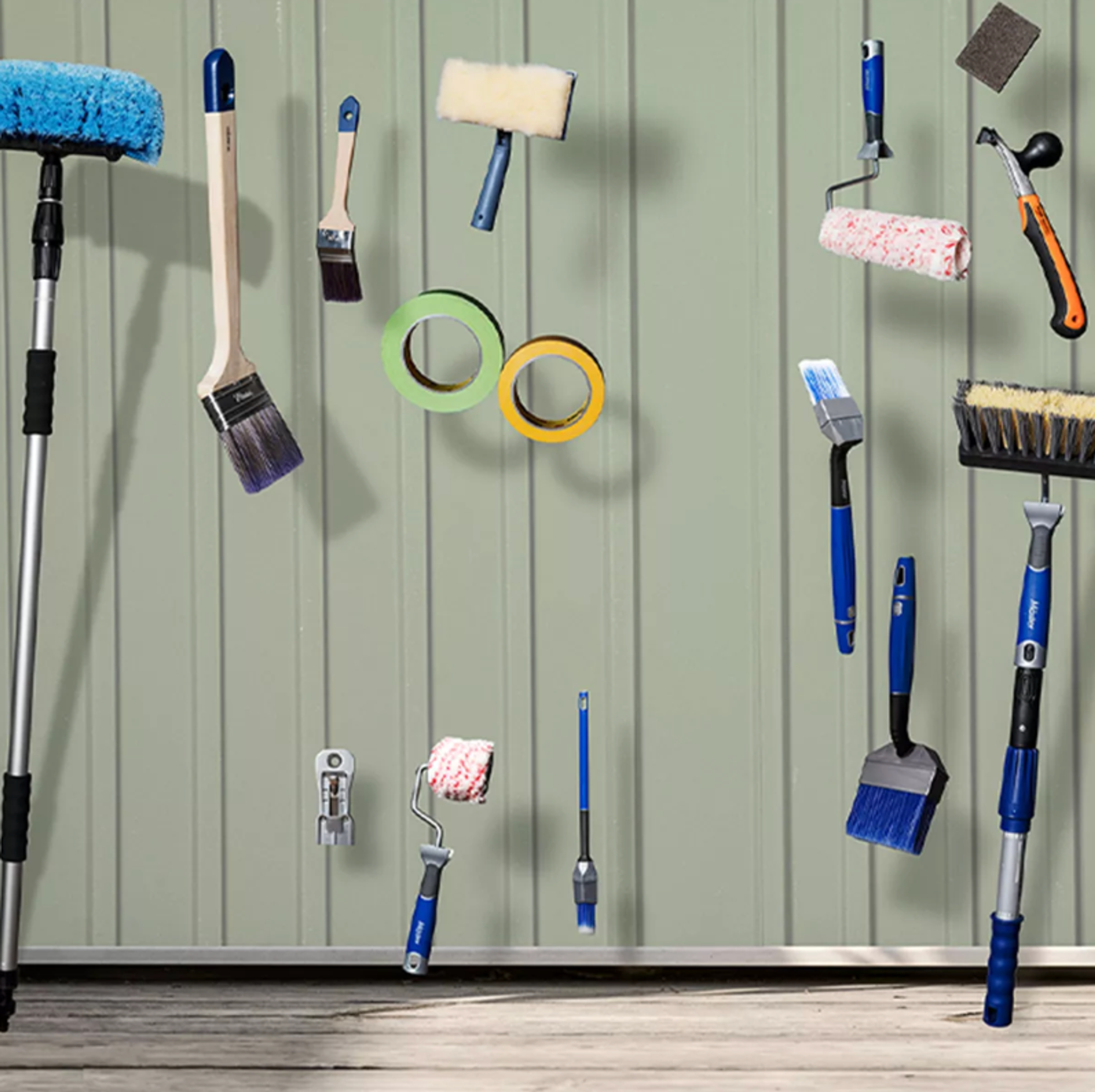 An array of painting tools, including brushes, rollers, and masking tape, float against a light green paneled wall.