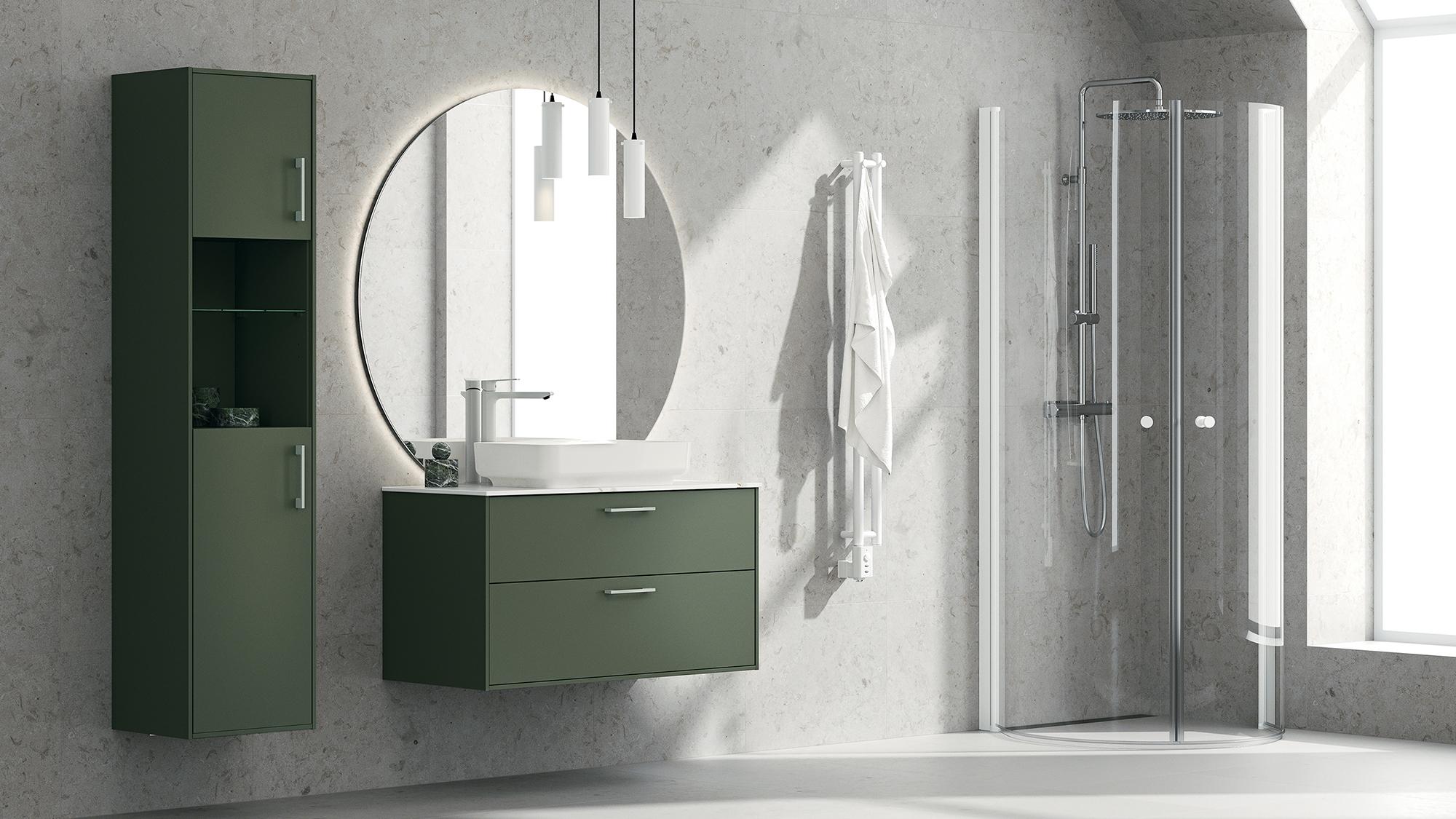 A modern bathroom with olive green cabinetry, a round backlit mirror, and a glass shower stall against a textured gray wall.
