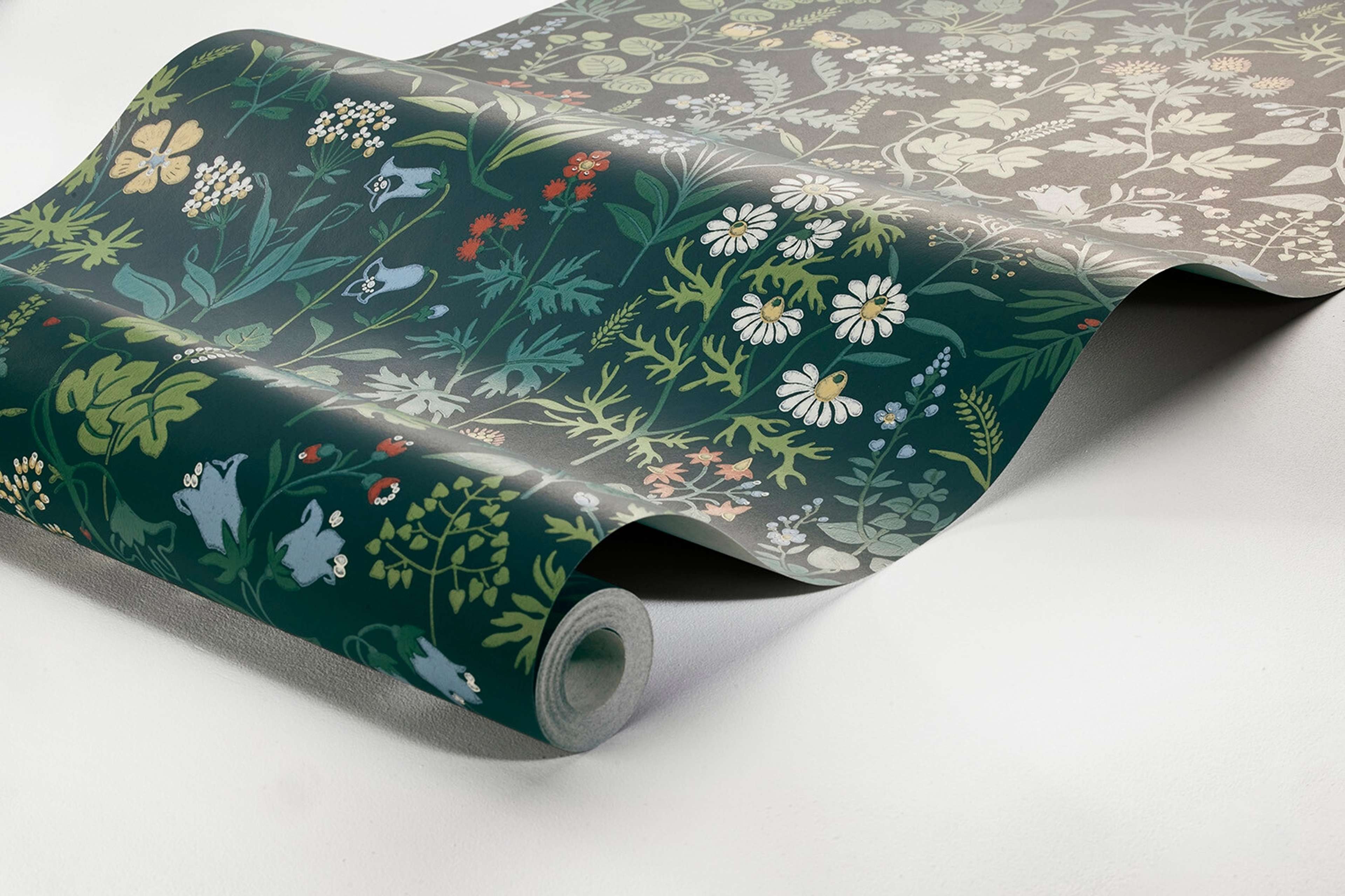 Flora tapet med blommigt mönster i svart. Från kollektionen Alla Tiders Hus. Nonwoven-material med förskjuten passning. Passar i vardagsrum, matsal och kök.