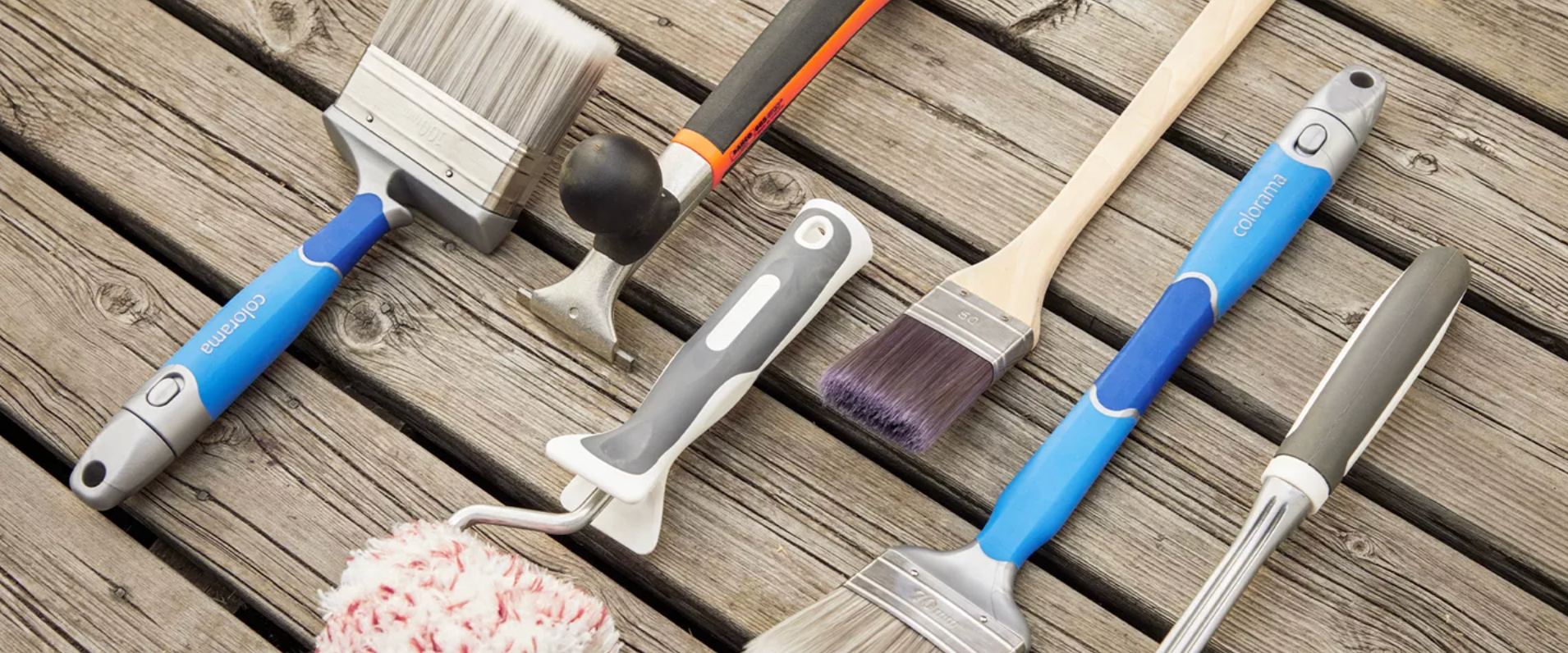 Assortment of new painting tools on wooden planks.