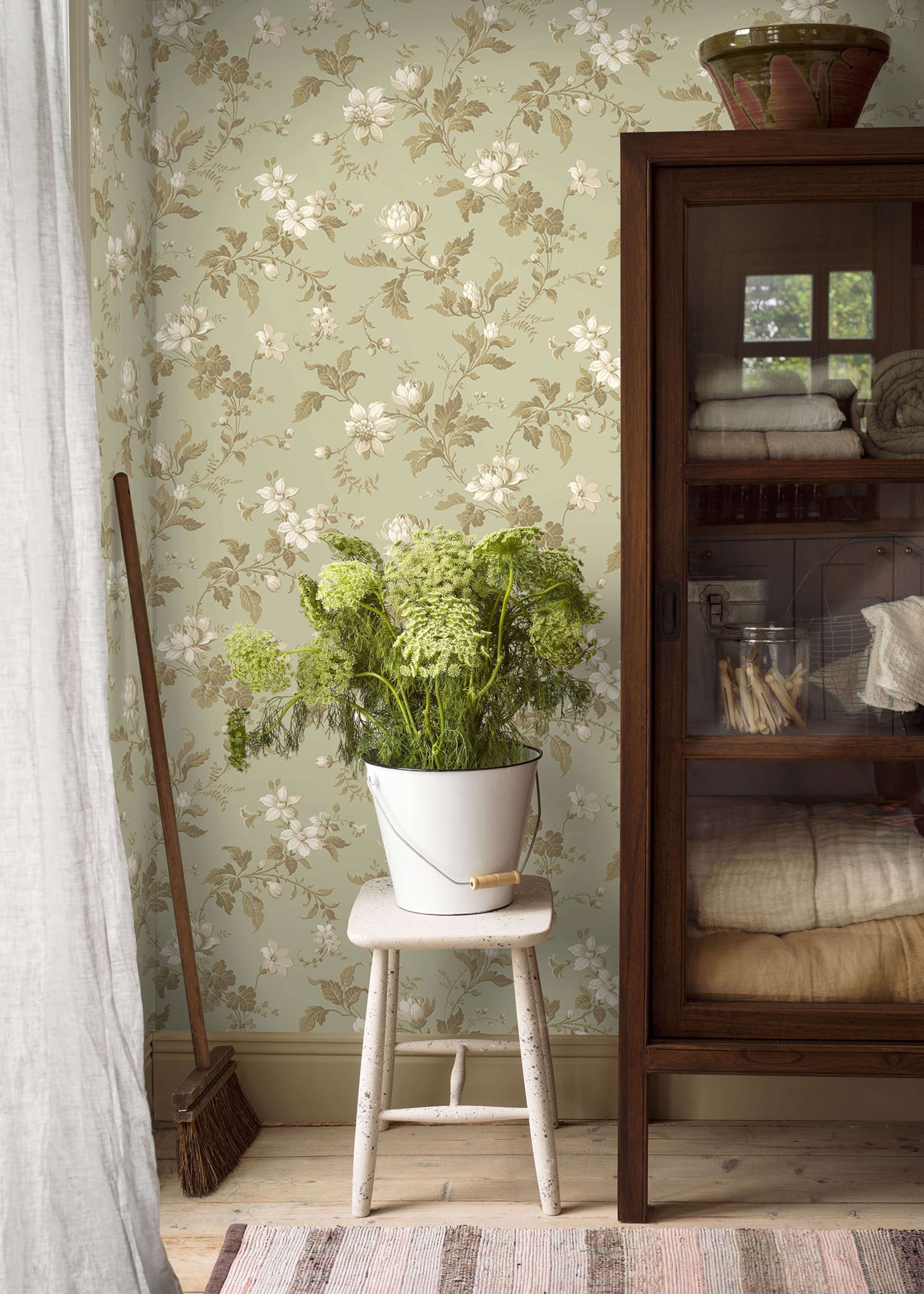Blomslinga, lindblomsgrön botten tapet från Boråstapeter med blommigt mönster i vit, grön och beige. Från kollektionen anno. Nonwoven-material med förskjuten passning. Passar i sovrum och matsal.