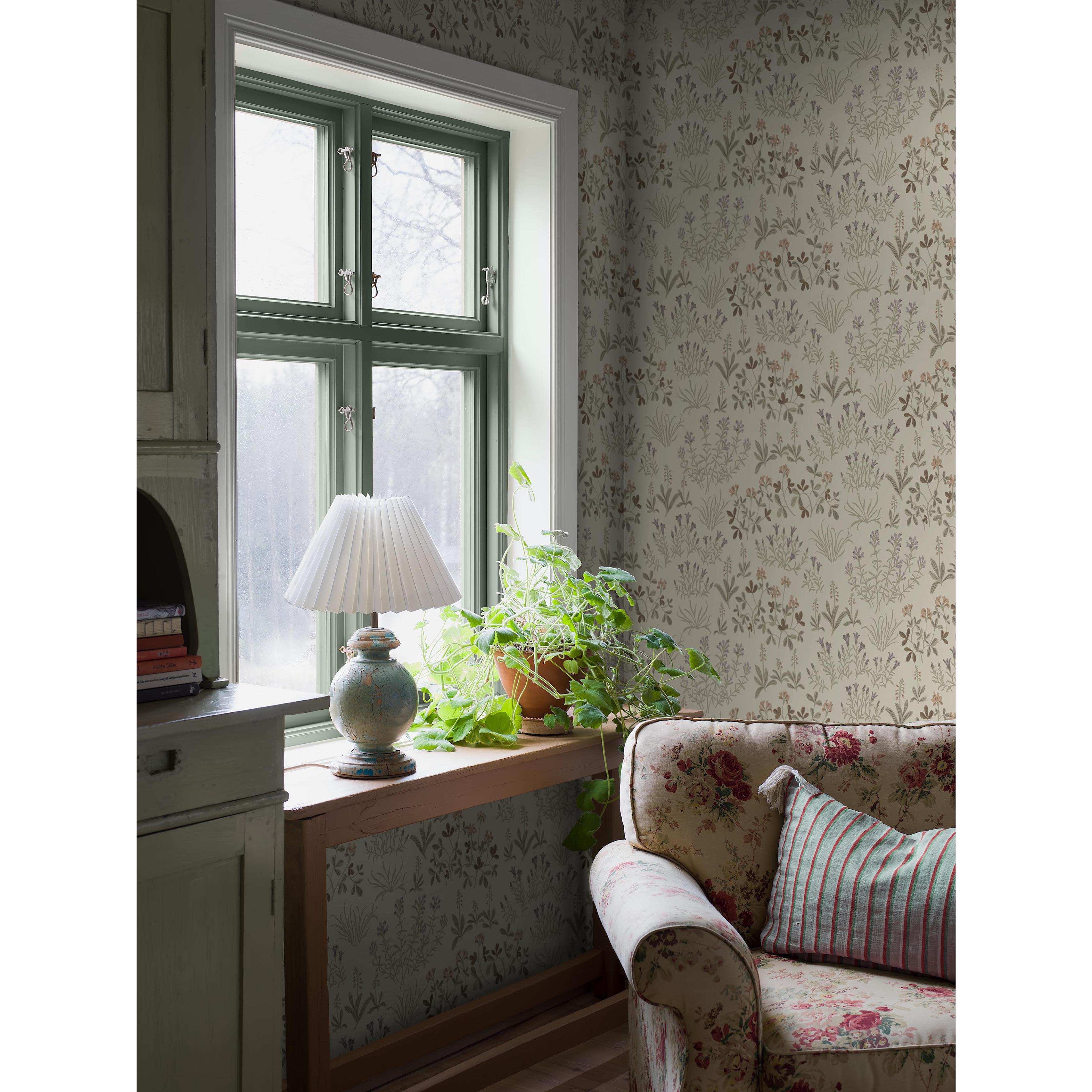 Noras Äng brun, tapet tapet med blommigt, naturochlandskap mönster i brun. Från kollektionen Nordic Folk. Nonwoven-material med förskjuten passning. Passar i vardagsrum.