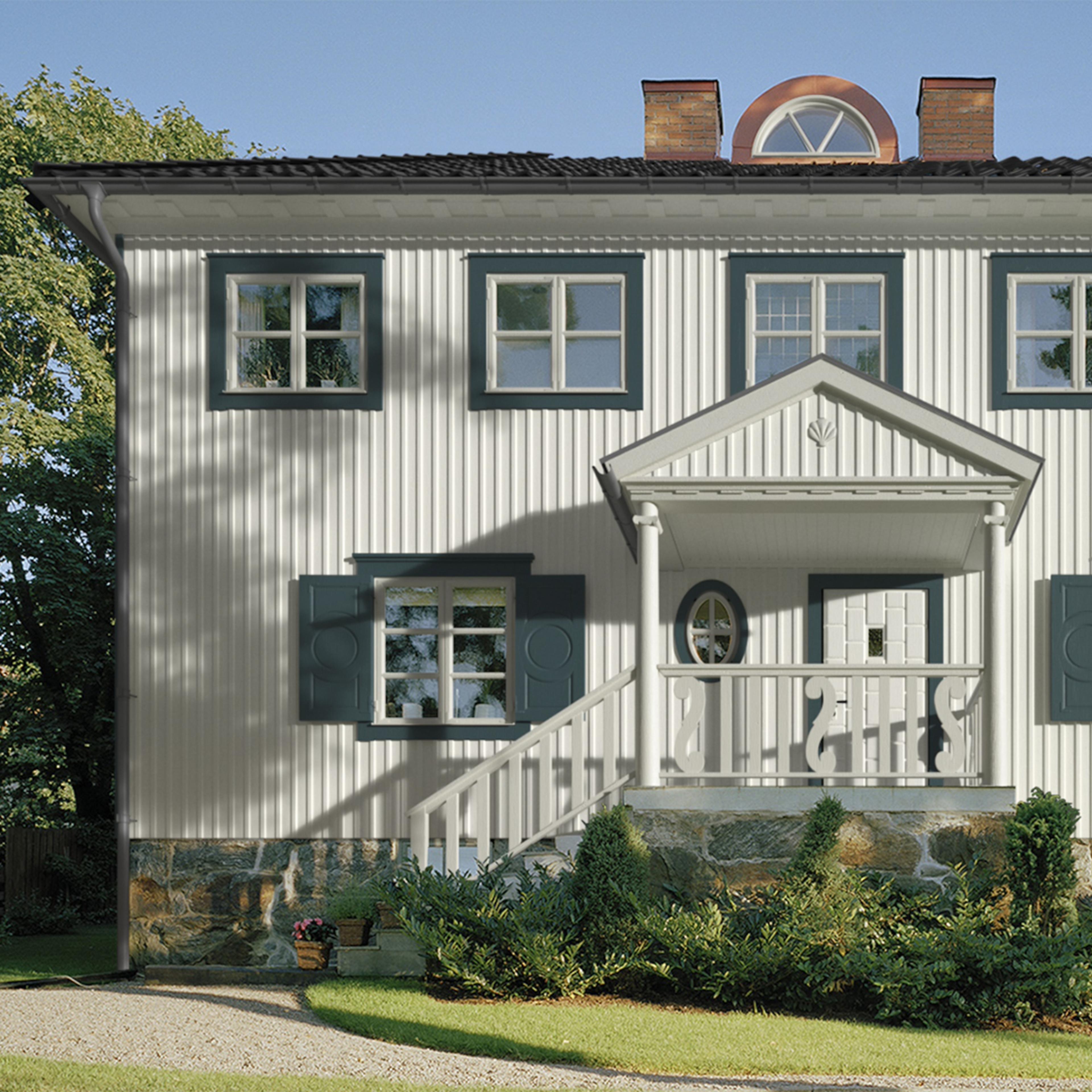 A white house with vertical siding, blue-green window trim, and a front porch.