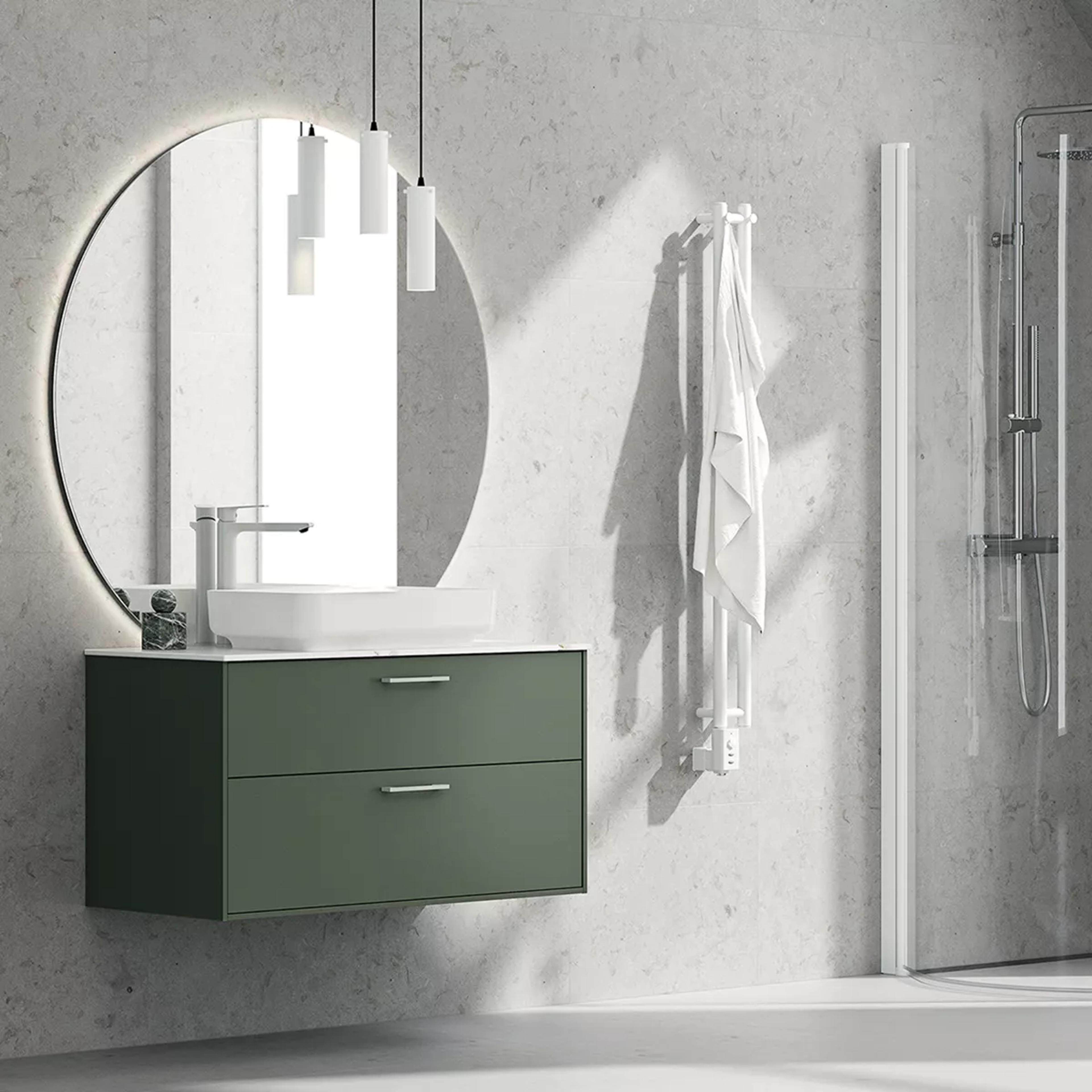 A modern bathroom with a floating olive green vanity, white basin, large round backlit mirror, towel warmer, and shower.