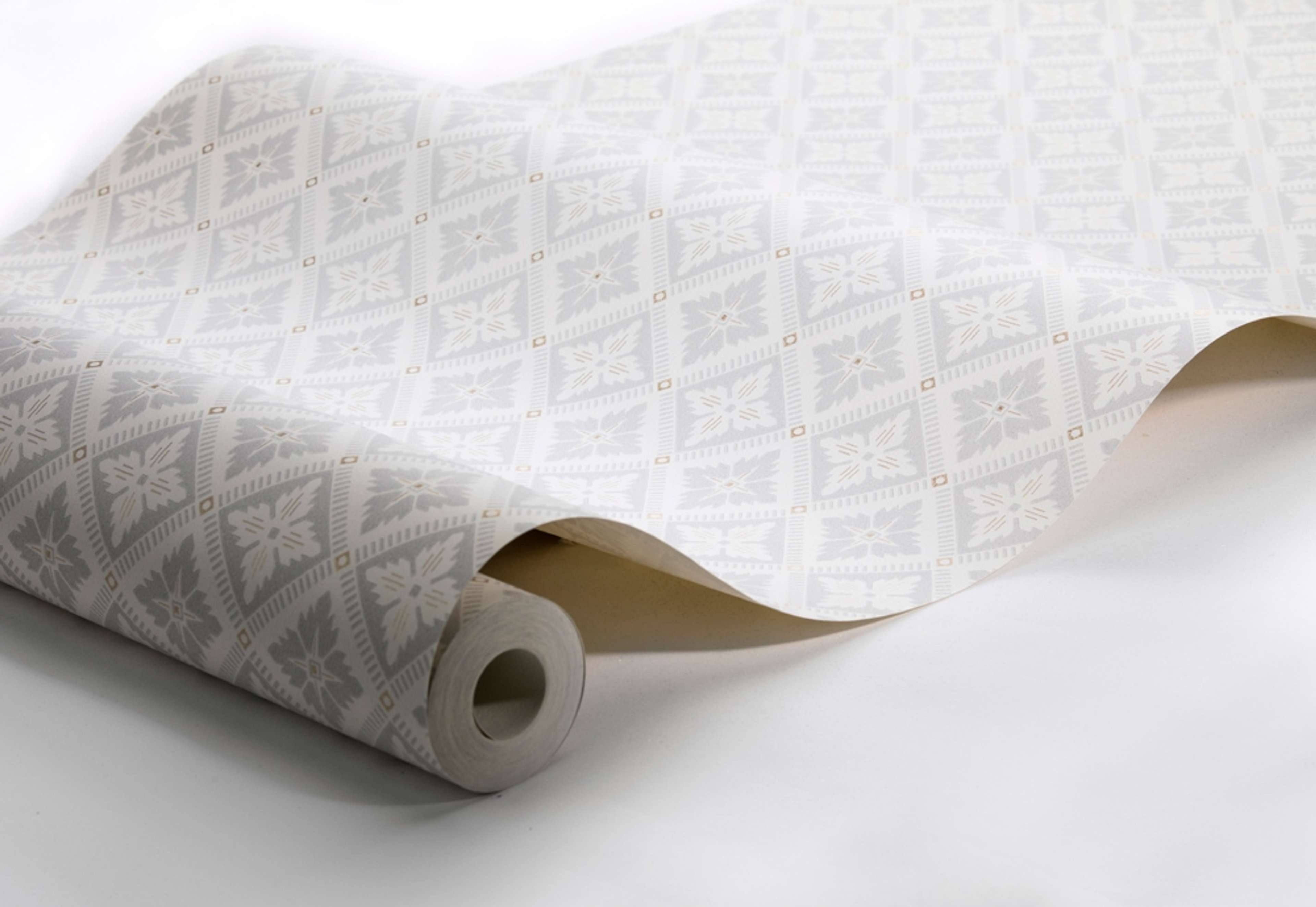 Loka, crémevit/ljusgrå tapet från Boråstapeter med geometriskt mönster i vit, guld och grå. Från kollektionen anno. Nonwoven-material med rak passning. Vintage, city-stil. Passar i sovrum och matsal.