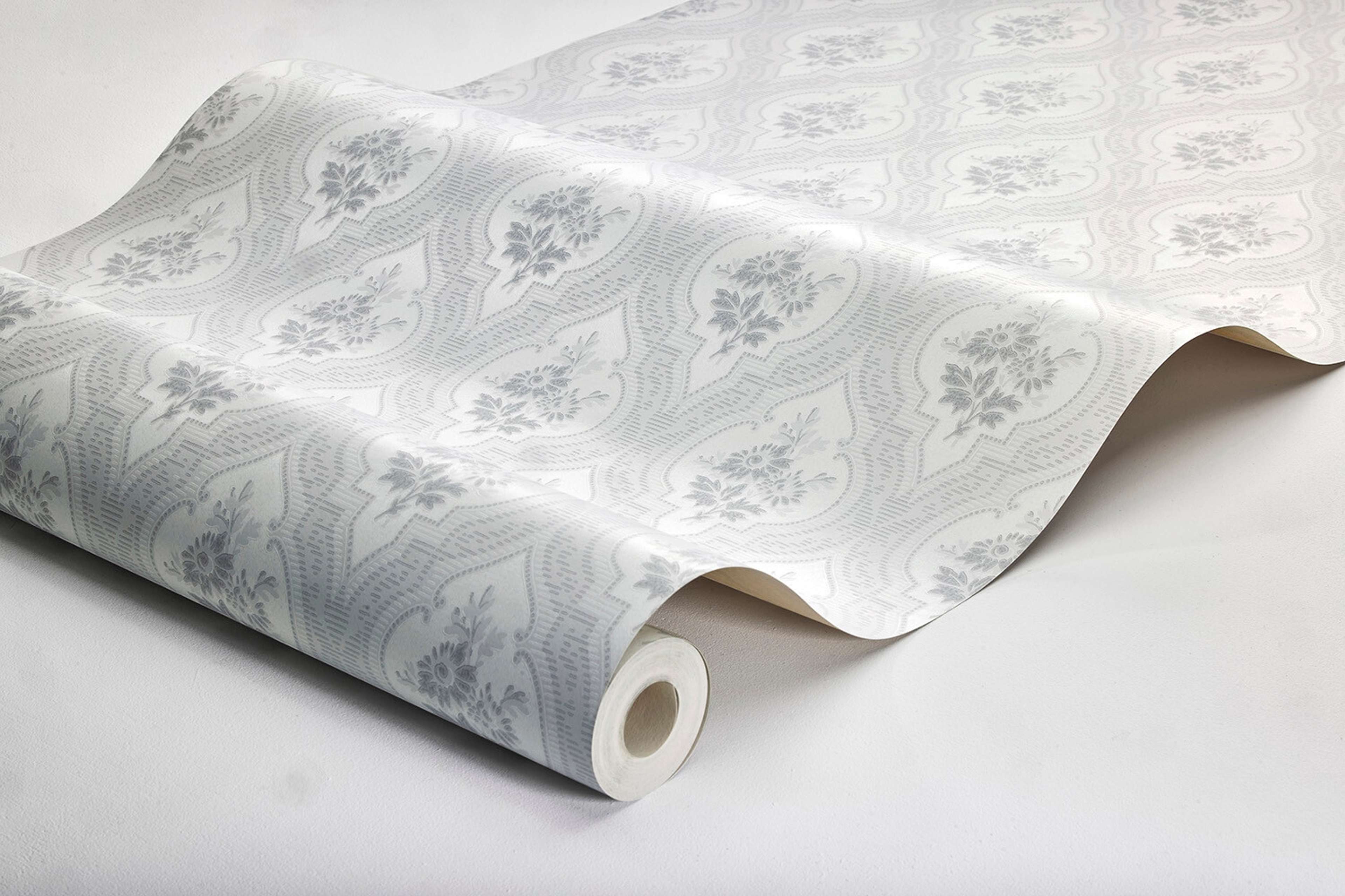Eternal Flower tapet tapet med blommigt, trellis mönster i grå. Från kollektionen Dreamy Escape. Nonwoven-material med förskjuten passning. Passar i vardagsrum och matsal.