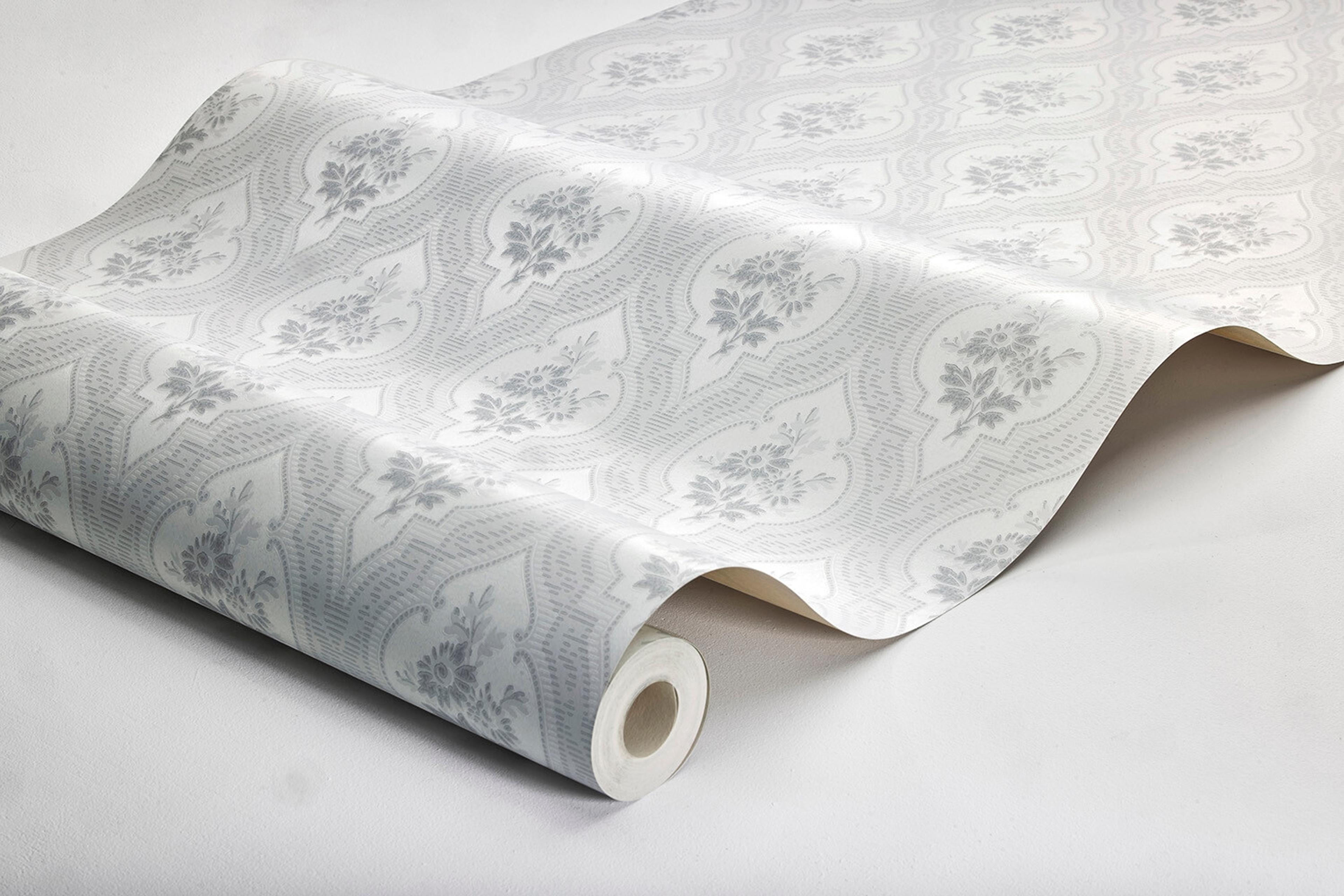 Eternal Flower tapet tapet med blommigt, trellis mönster i grå. Från kollektionen Dreamy Escape. Nonwoven-material med förskjuten passning. Passar i vardagsrum och matsal.