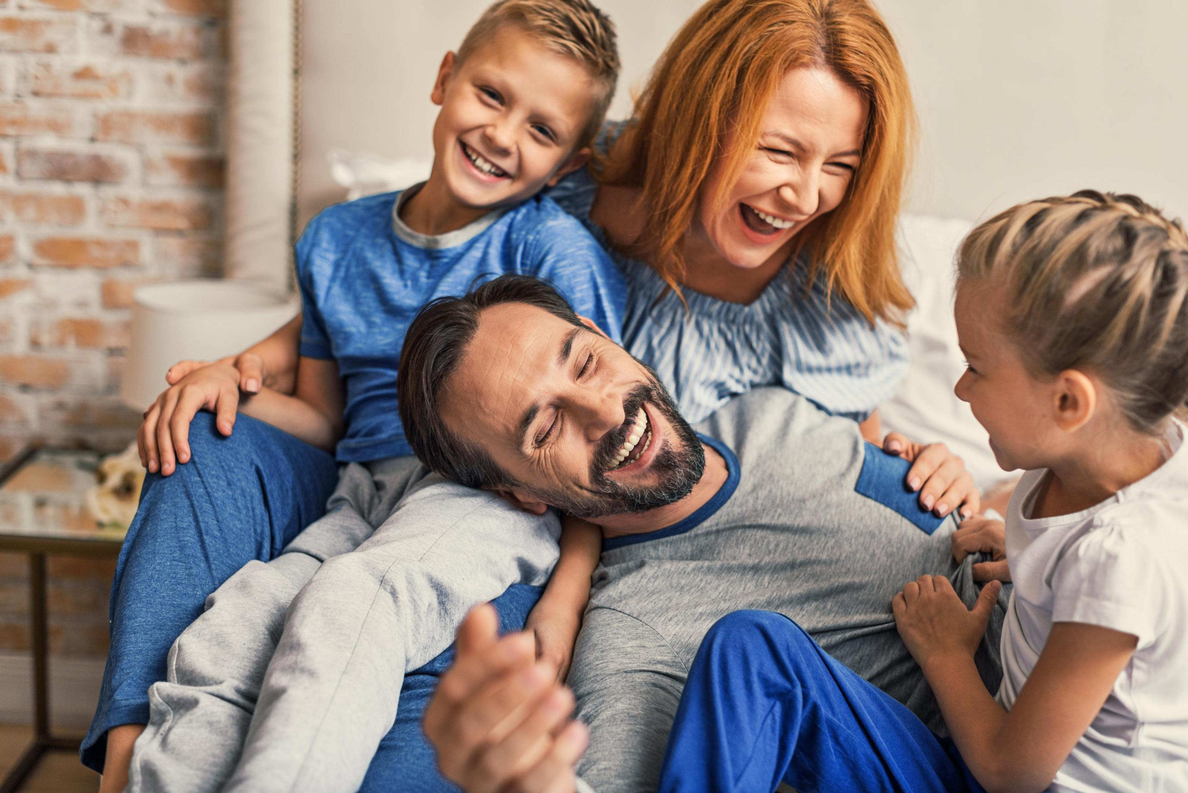 Bildet viser en smilende og glad familie på fire