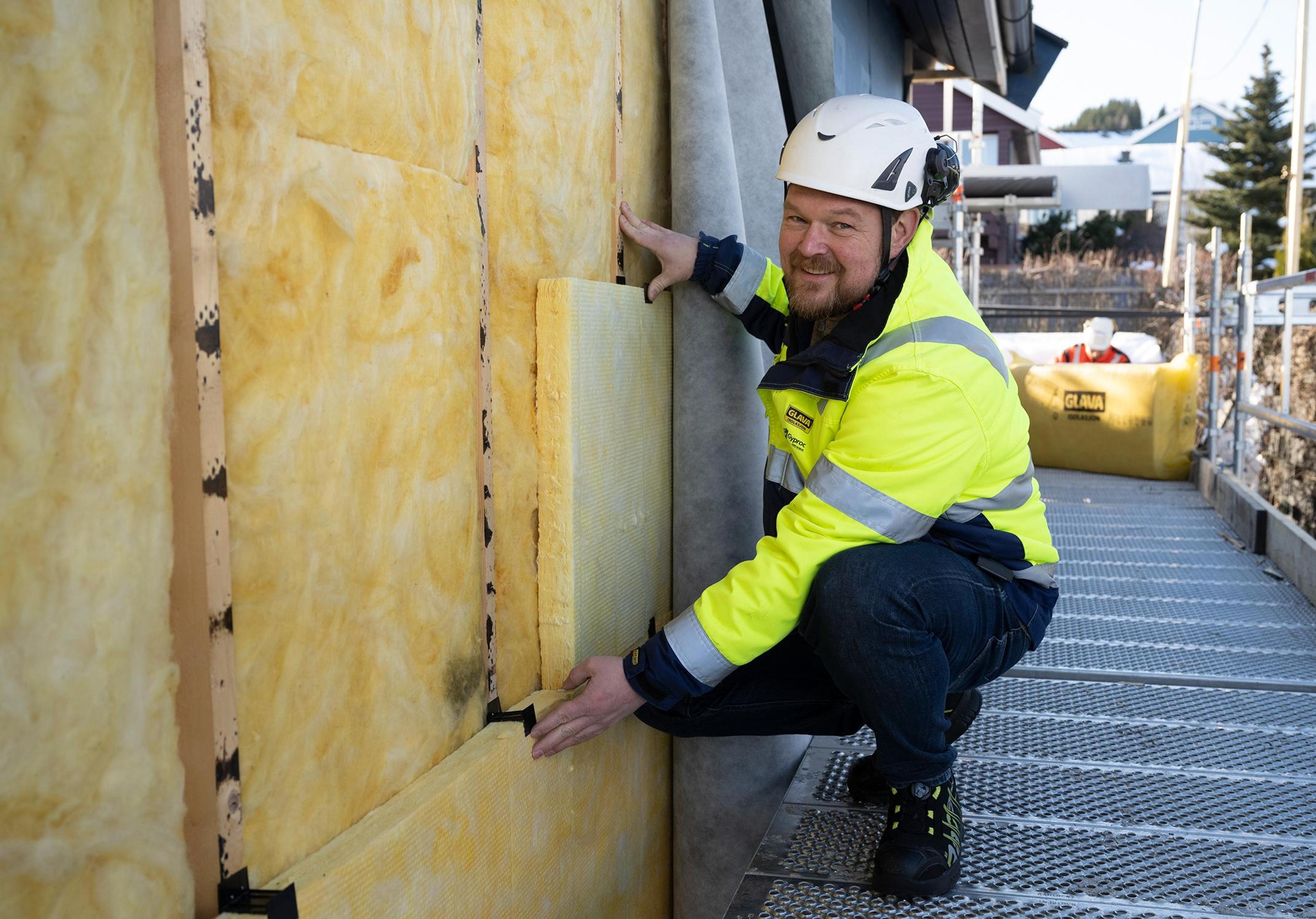 Håndverker som isolerer med Glava