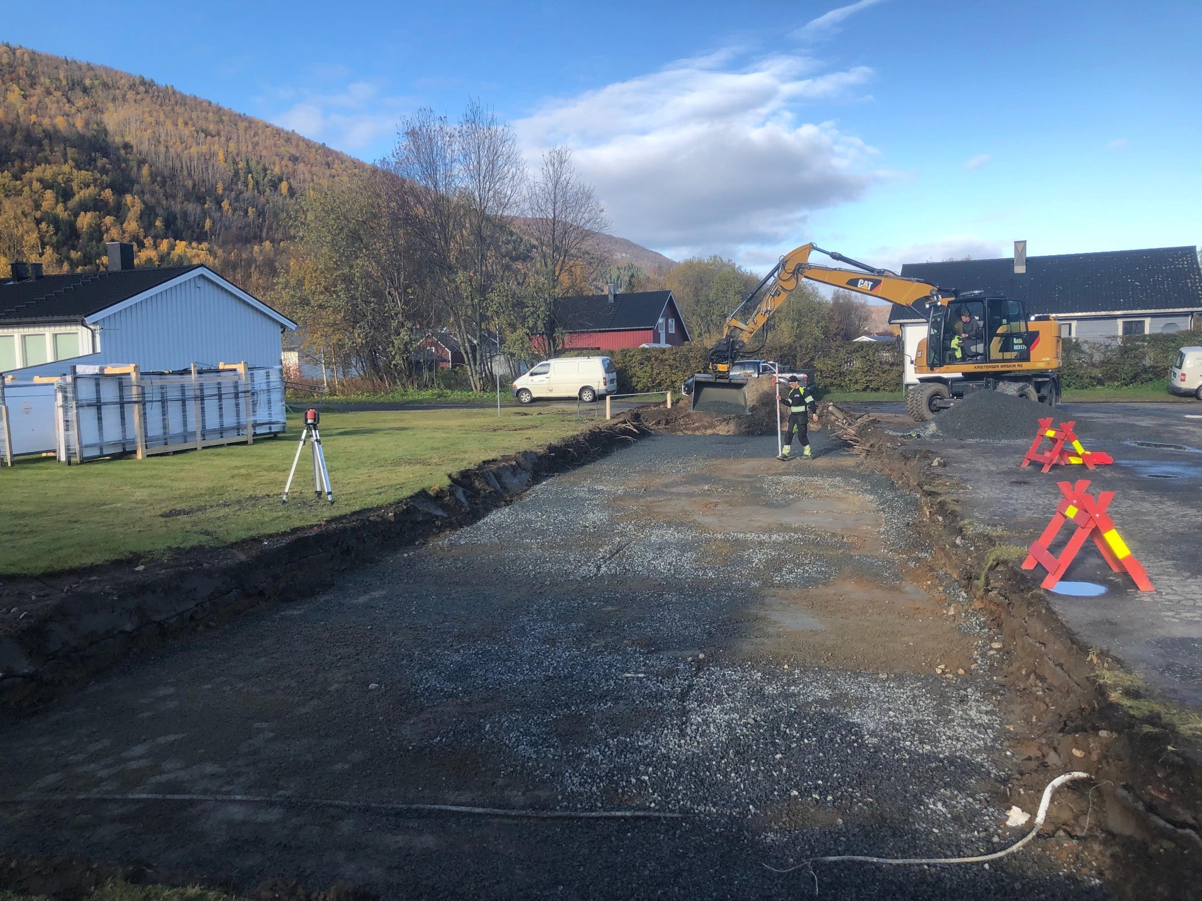 Byggeplass med kran og fjell i bakgrunn