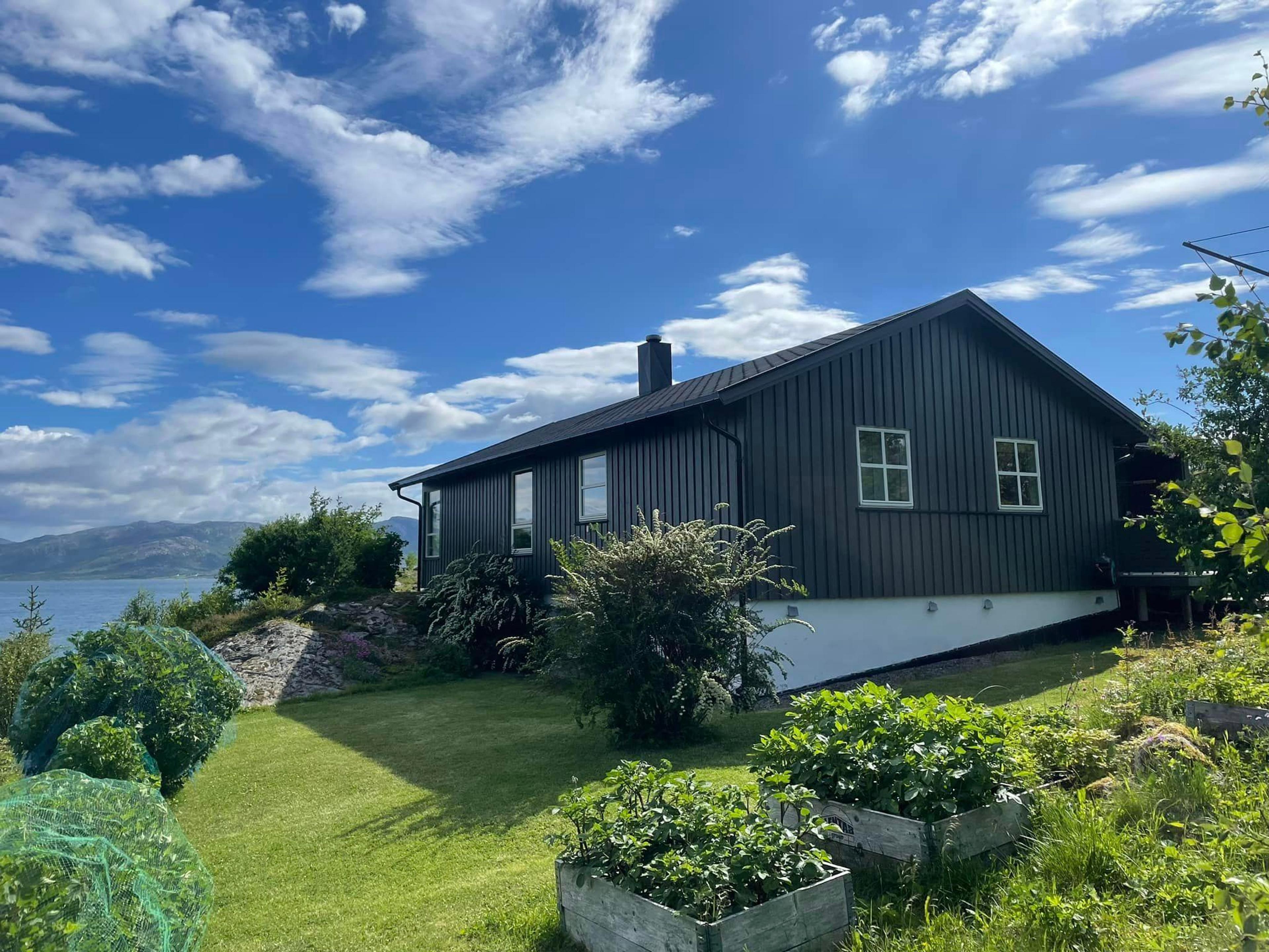 Svart ny hytte med gressplen