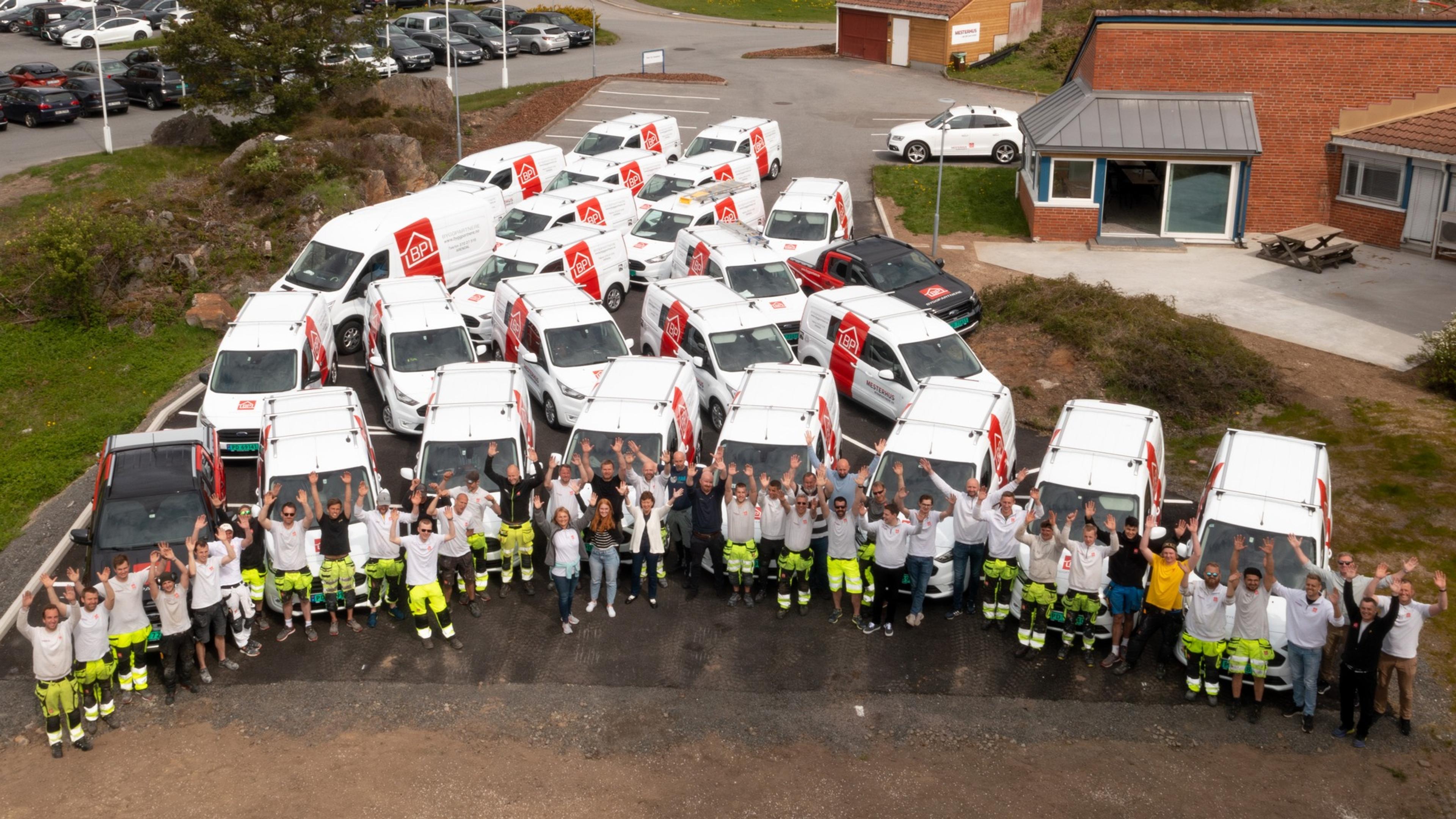 Gruppebilde ansatte med firmabiler bak