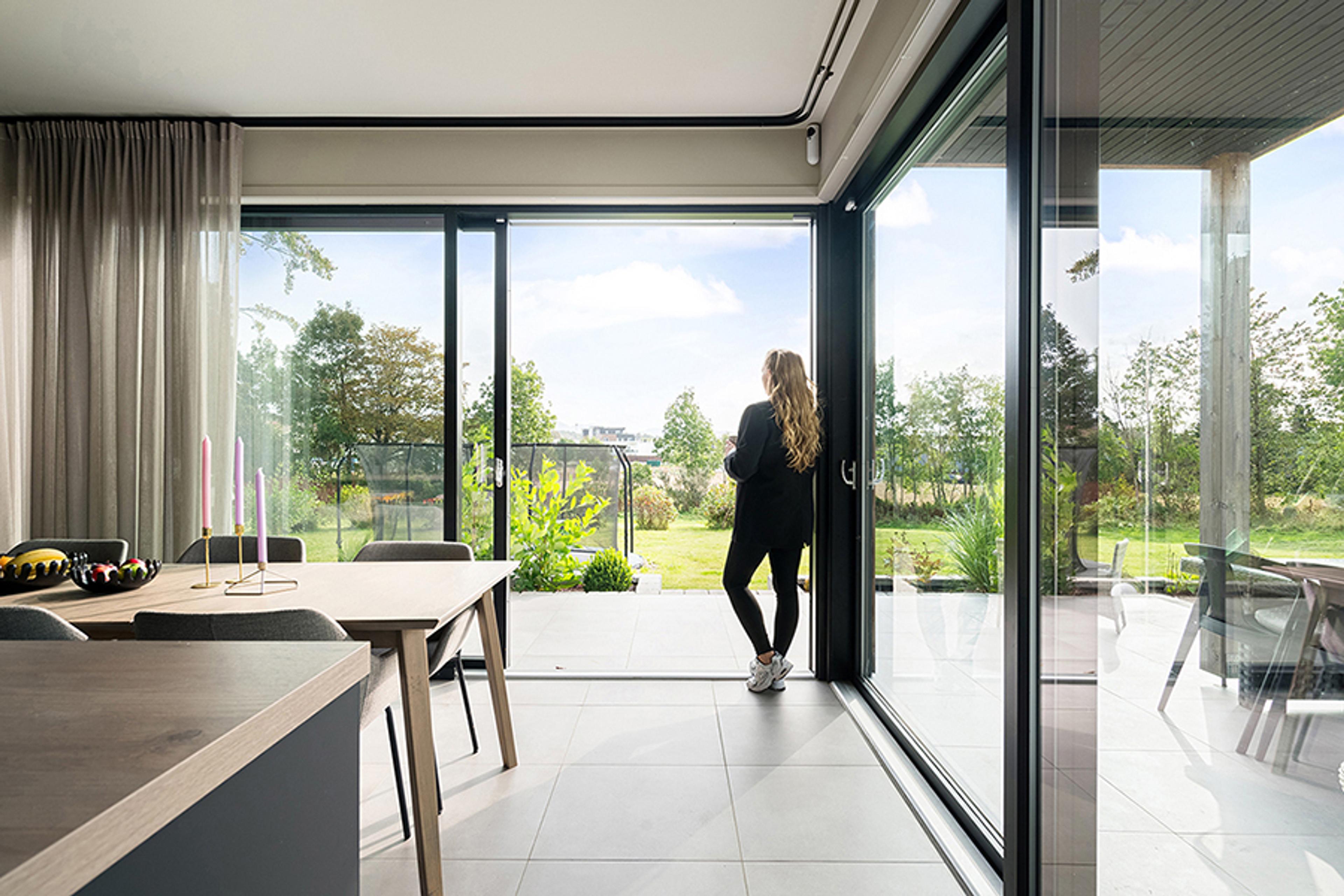 En dame som står ved vinduet og ser ut