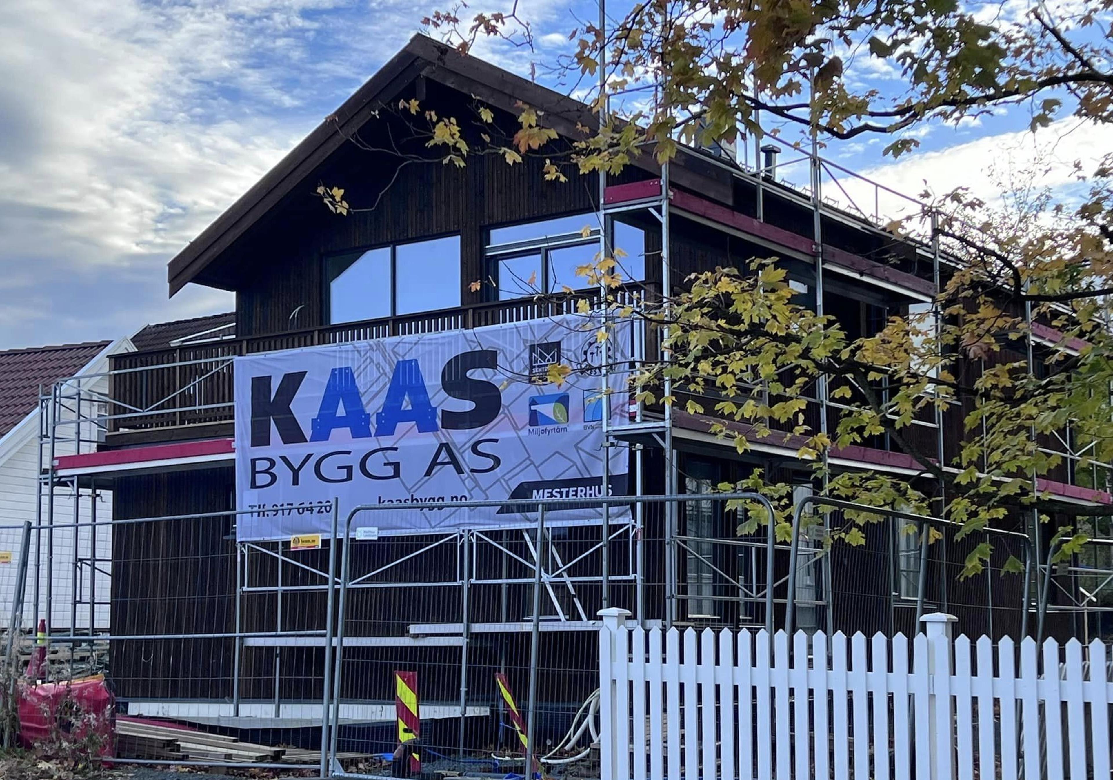 Svart hus med stor Kaas Bygg AS logo utenfor på stilas