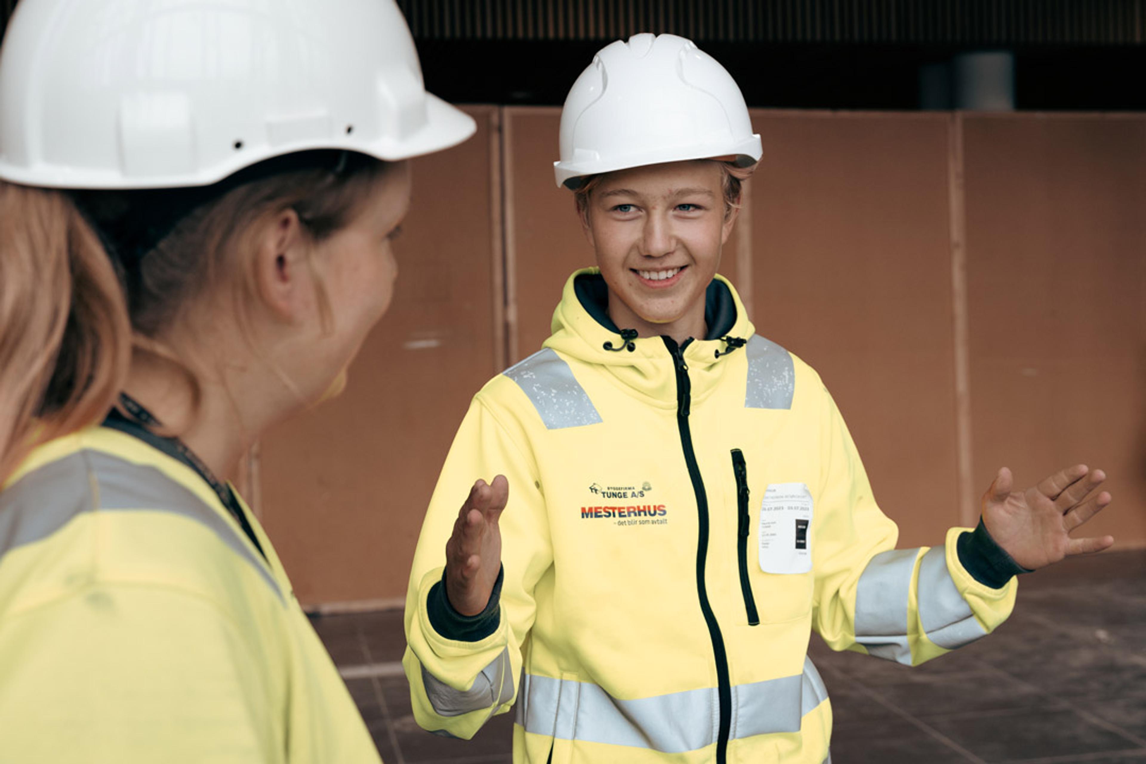 To arbeidere med hjelm og firmajakke